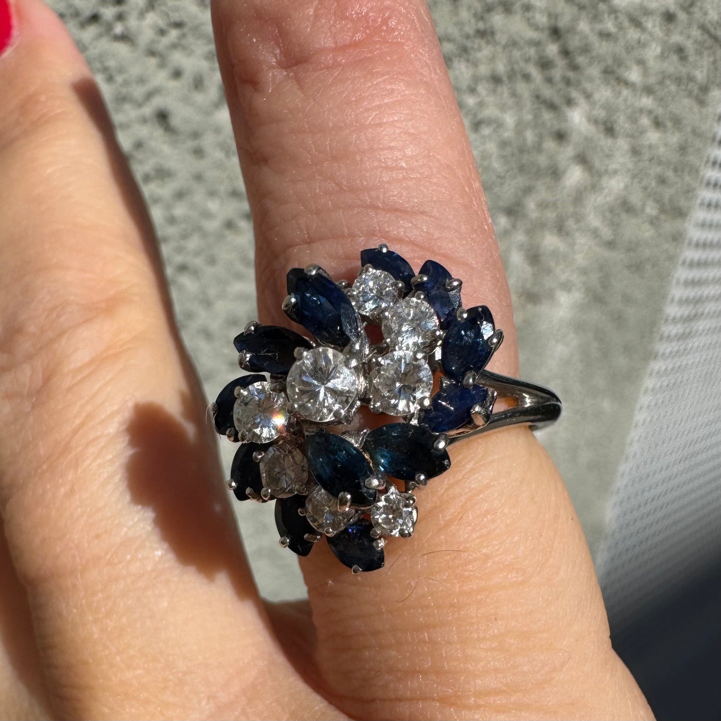 18K white gold ring, set with marquise-cut blue Sapphires and round Diamonds, in a classic cluster design.