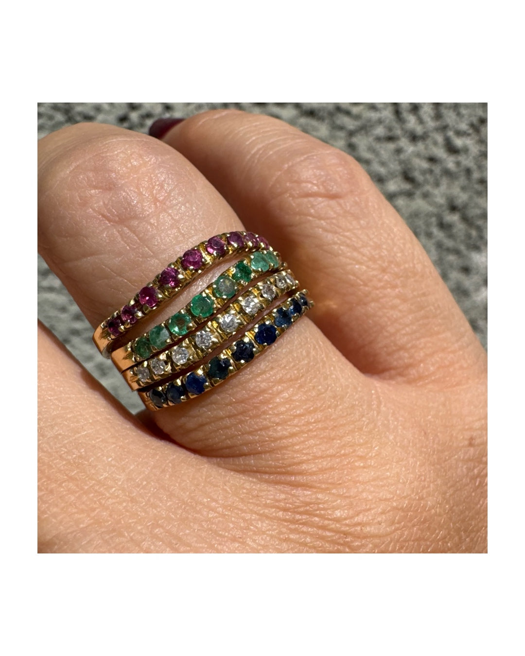 טבעת זהב צהוב 18 קראט, משובצת בשורות צבעוניות של ספירים, אמרלדים, רובינים ויהלומים – פריט אלגנטי מלא חיים וזוהר.