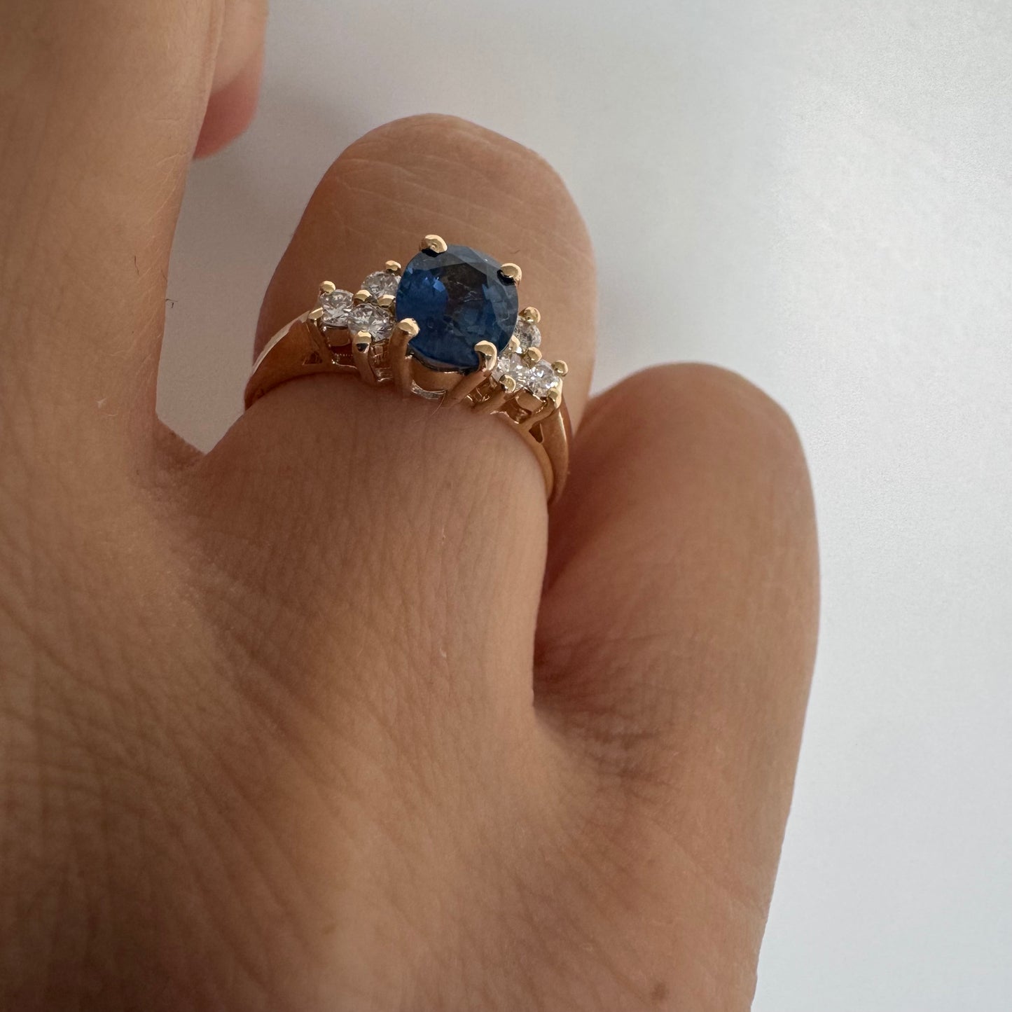 14K gold ring set with an oval blue Sapphire at the center & Diamonds