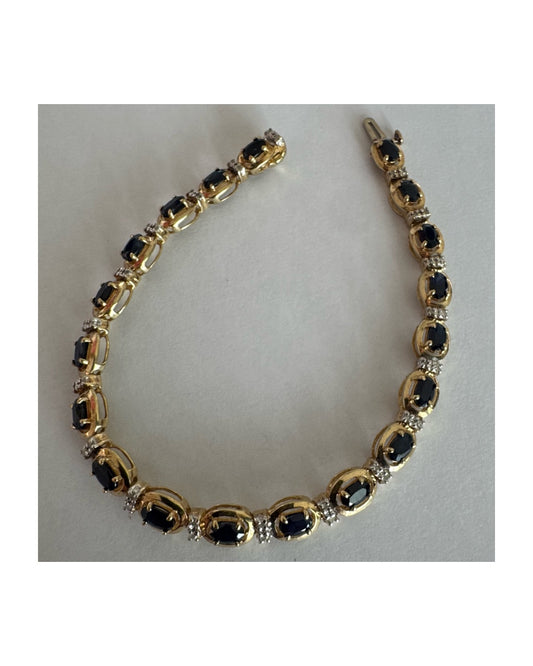 צמיד זהב צהוב 10 קראט בעיצוב קלאסי ועשיר, משובץ אבני ספיר אובליות בגוון כחול עמוק וביניהן שיבוצי יהלומים לבנים עדינים.