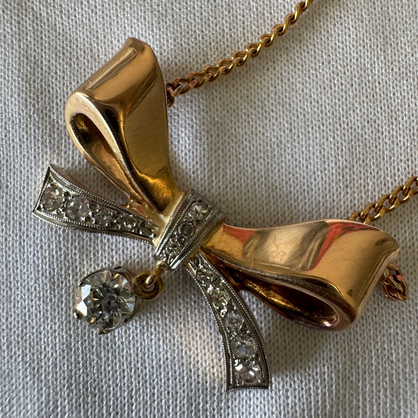 שרשרת זהב 18 קראט עם תליון בצורת סרט קלאסי משובץ יהלומים ונושא יהלום מרכזי תלוי שמוסיף נגיעה של זוהר ואלגנטיות