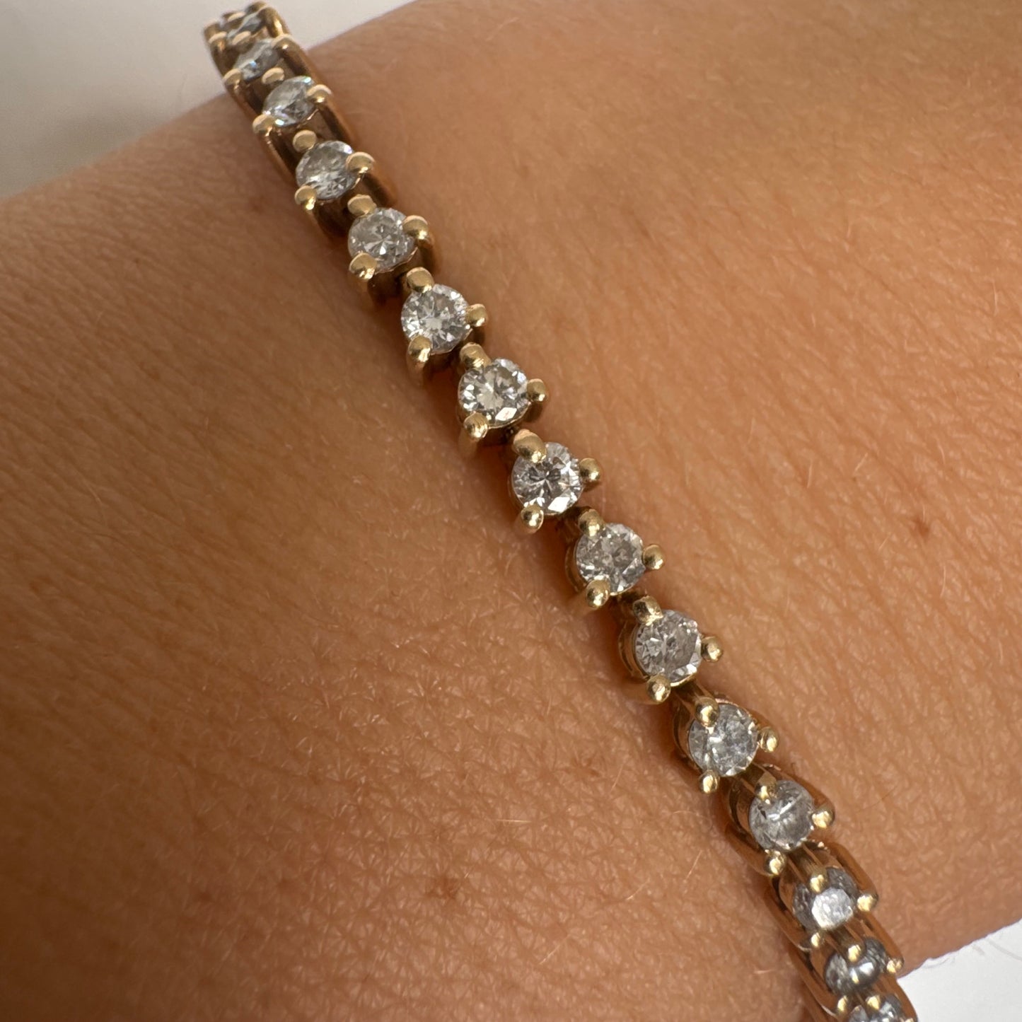 14K gold tennis bracelet set with a continuous line of round Diamonds, creating a delicate and elegant sparkle.
