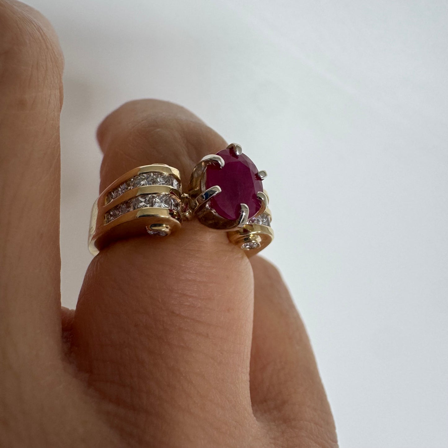 14K gold ring set with a vivid natural Ruby at the center and accented by rows of Diamonds on both sides.