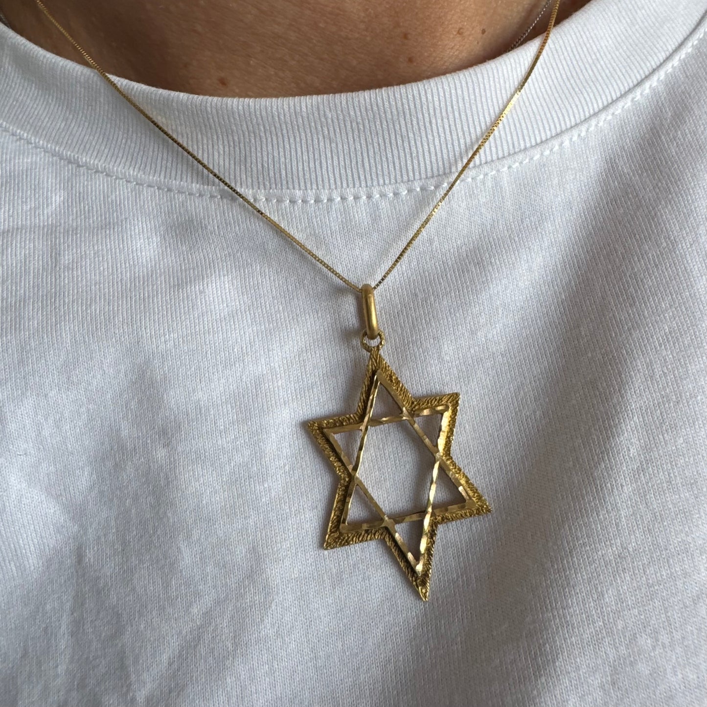 14K gold Star of David pendant with textured detailing and an open design.