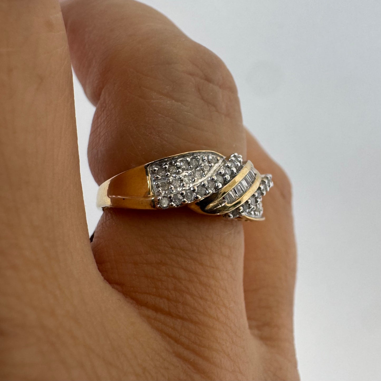 10K gold ring set with round-cut Diamonds and a central row of baguette Diamonds.