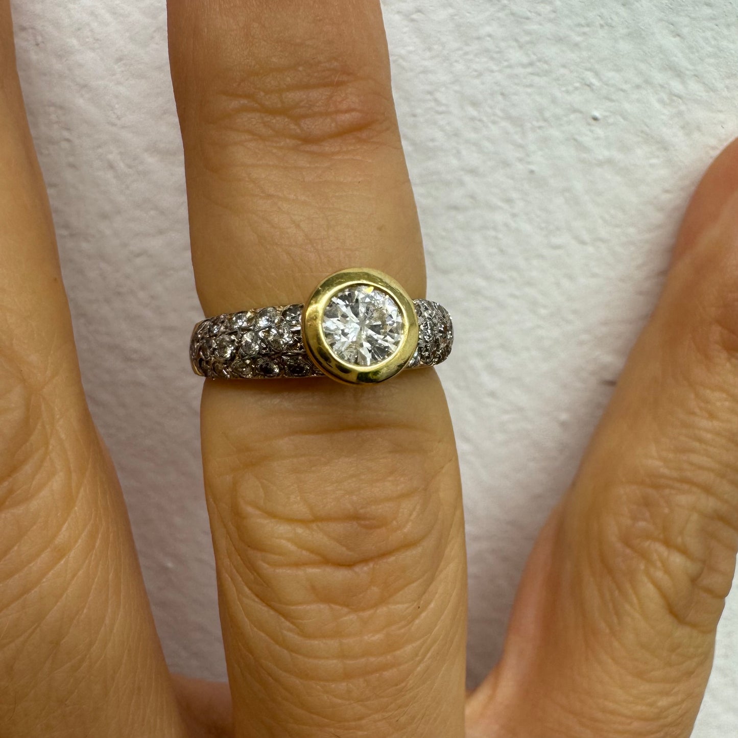 טבעת זהב צהוב 14 קראט משובצת יהלום עגול ויהלומים נוספים על הרצועה.