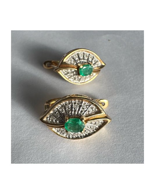 עגילים צמודים לאוזן, זהב צהוב 14 קראט, משובצים אמרלד במרכז, וסביבן פיתוחים משובצים יהלומים, שמעניקים מראה של ניצוץ רך ואלגנטי