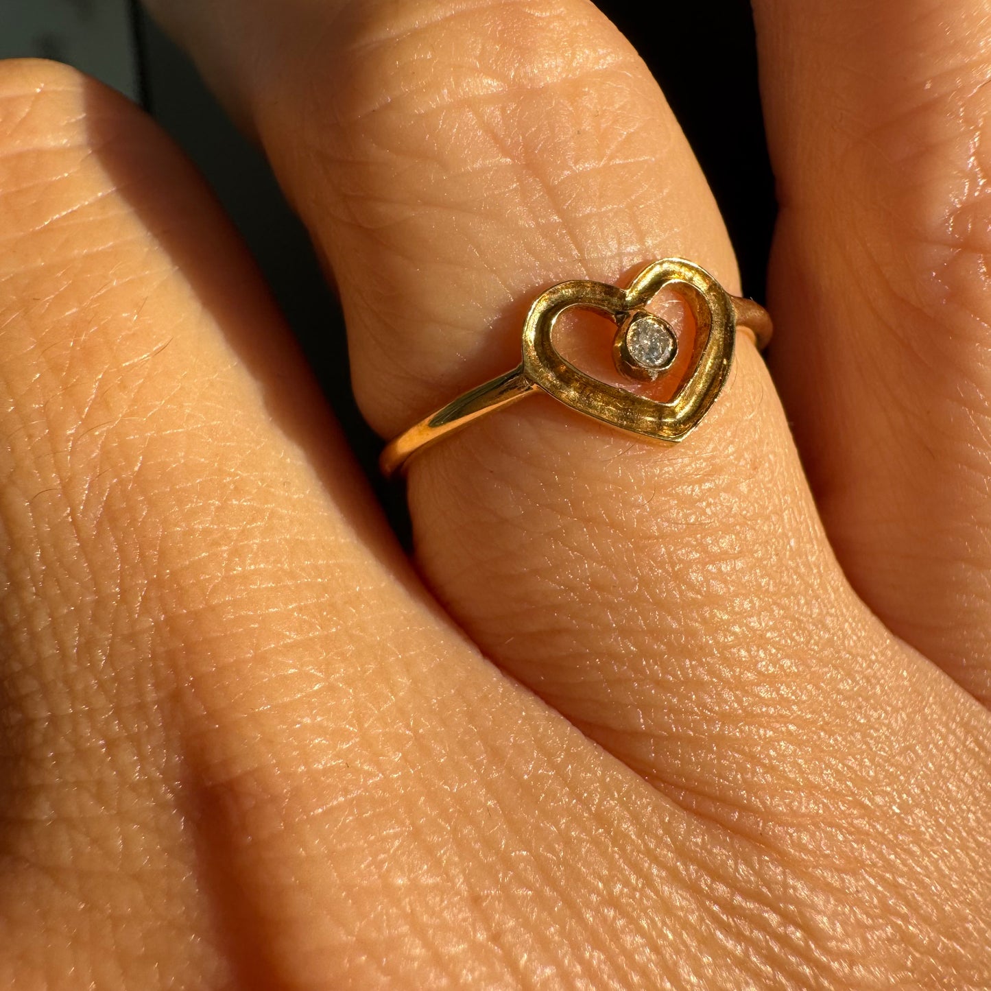 טבעת זהב 14 קראט בעיצוב לב פתוח ועדין, עם יהלום קטן במרכז שמוסיף נקודת אור אלגנטית. 