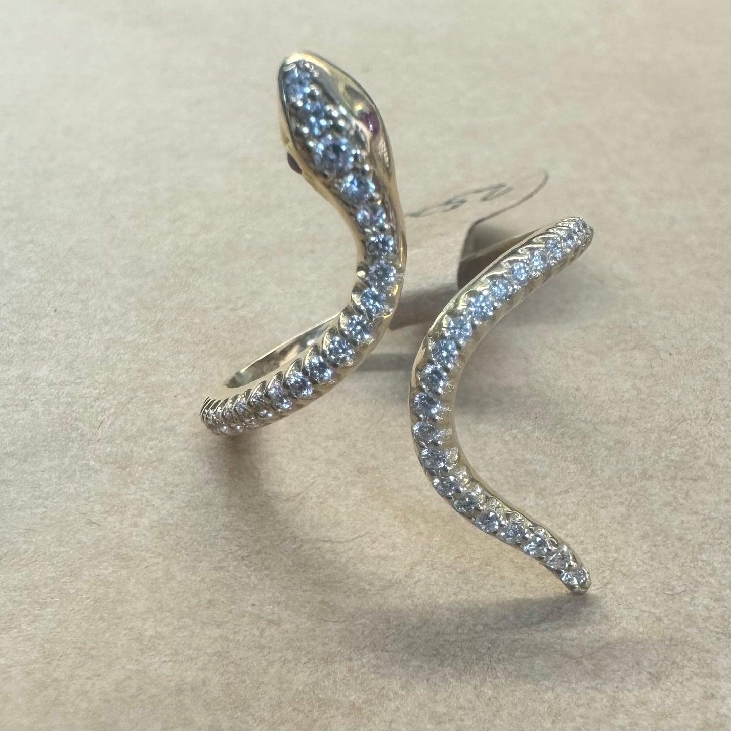 14K gold wrap-around snake ring, fully set with sparkling Diamonds along its body and head, finished with Rubies eyes