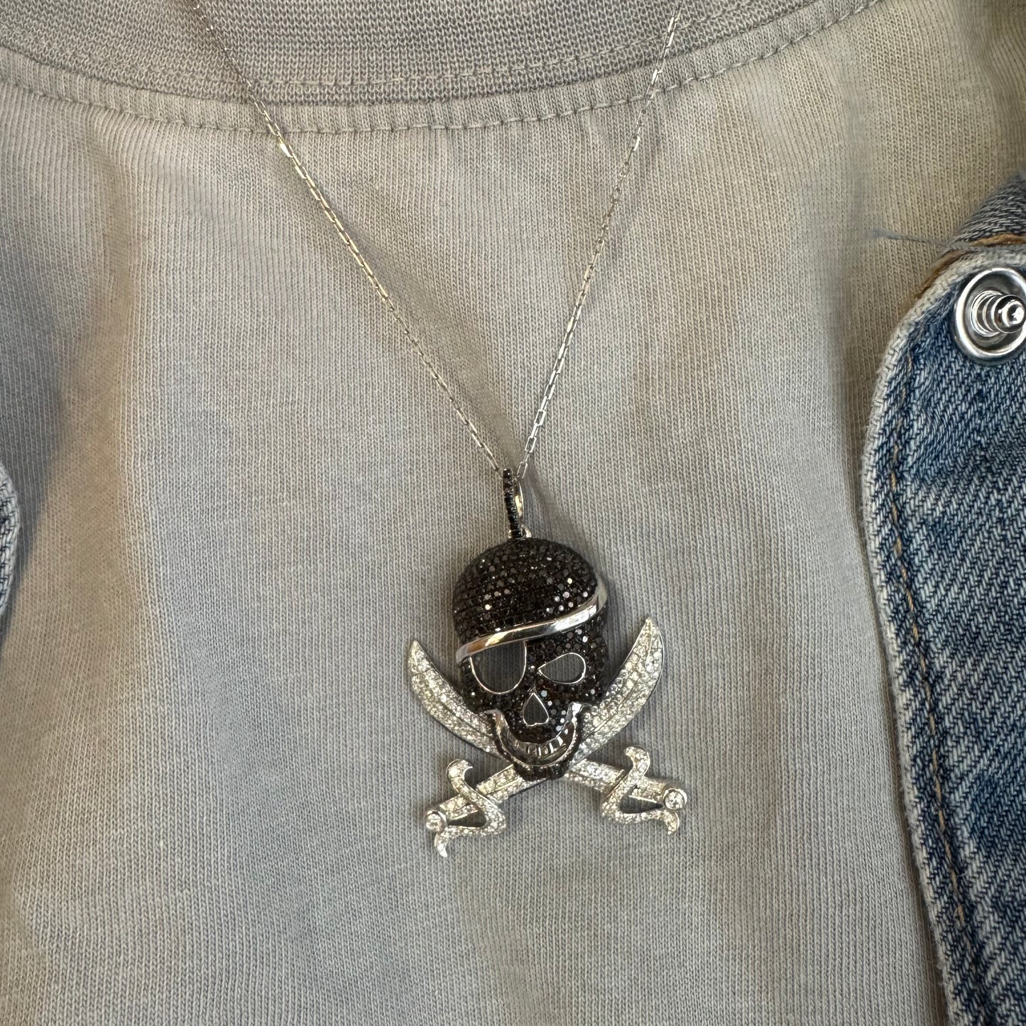 תליון זהב 14 קראט בצורת גולגולת/פיראט משובץ יהלומים לבנים ויהלומים שחורים בשיבוץ פאבה צפוף.