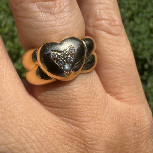 18K gold ring featuring a bold heart design, set with sparkling Diamonds in the center.