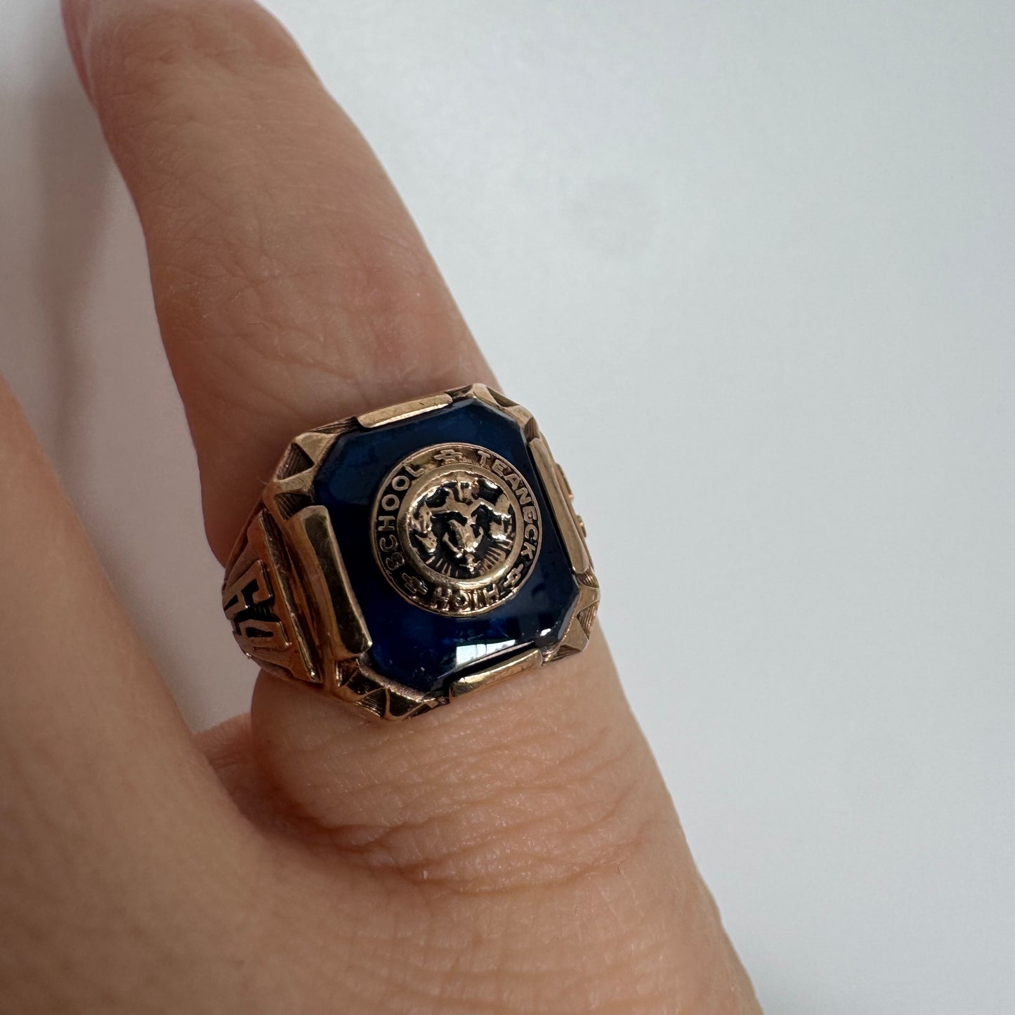 10K gold signet-style ring featuring a deep blue stone set with a raised “School & Teamwork” emblem at the center.