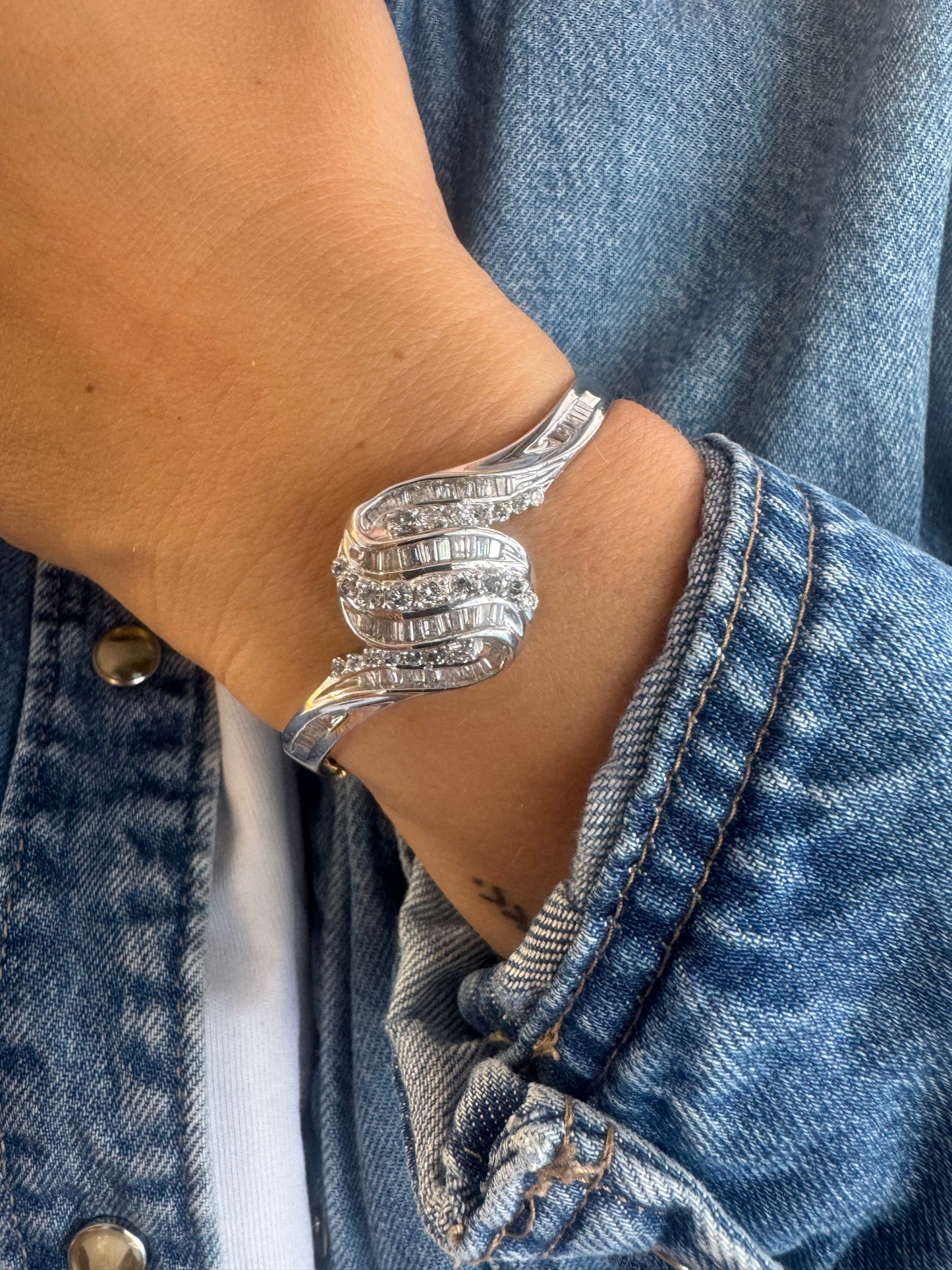 14K gold Hard bracelet featuring a flowing wave design, set with a dazzling mix of round and baguette-cut Diamonds