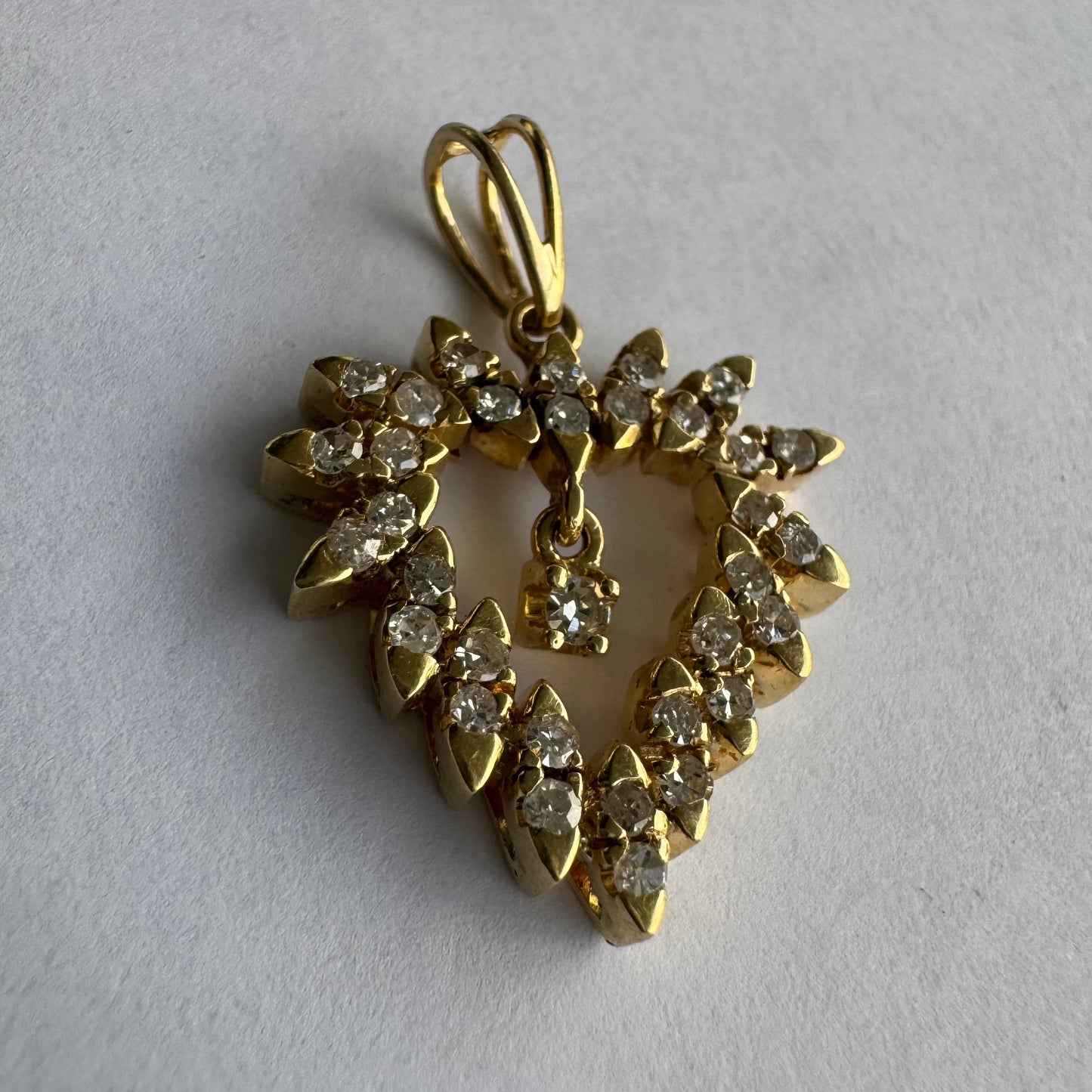 תליון זהב צהוב 14 קראט בצורת לב, משובץ יהלומים בסידור עדין היוצר מראה עשיר ומלא ברק.