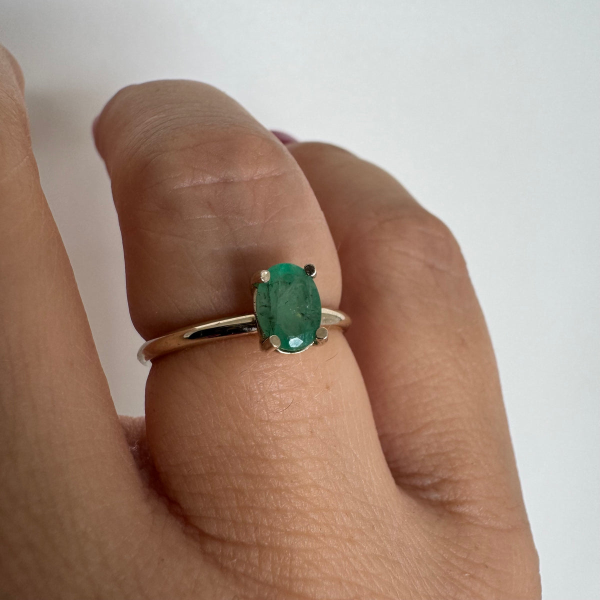 14K gold ring set with an oval-cut Emerald
