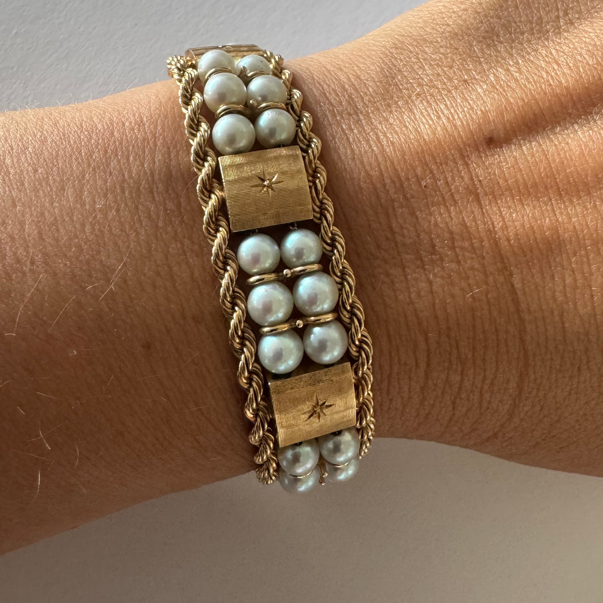 14K gold bracelet set with Pearls, featuring intricate rope-style detailing and textured geometric gold elements.