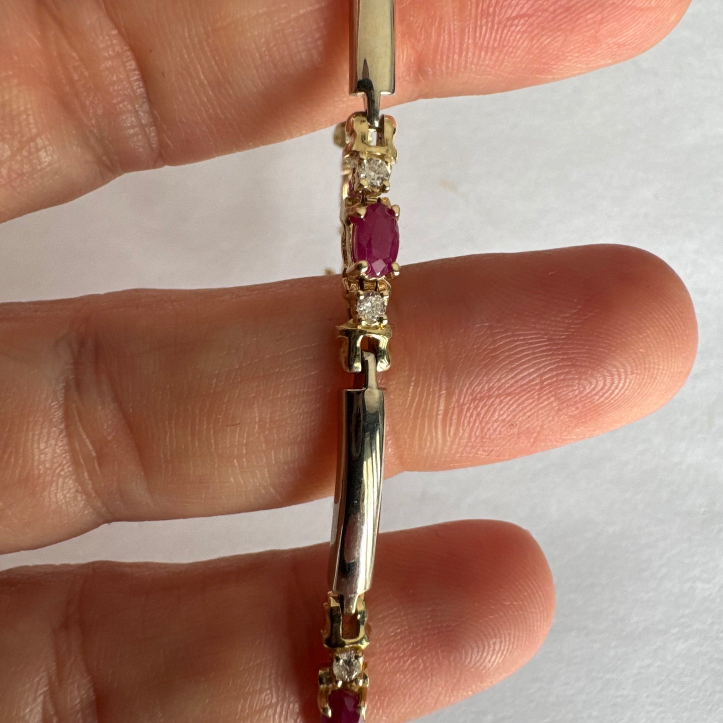 צמיד זהב צהוב 14 קראט משובץ אבני רובי אדומות בחיתוך אובלי, עם יהלומים המשובצים ביניהן להוספת ברק עדין.