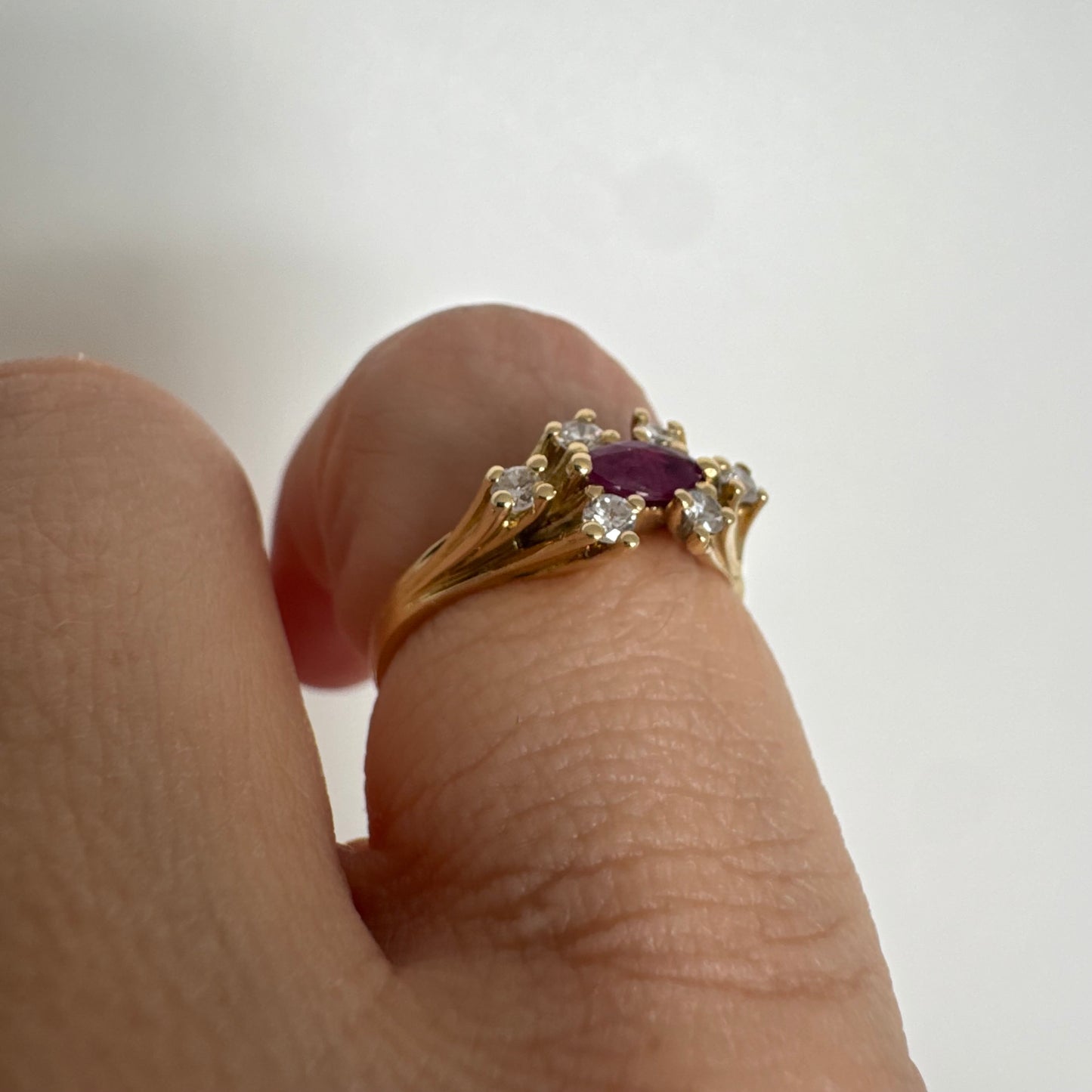 18K gold ring set with a marquise-cut Ruby accented by round Diamonds on each side.