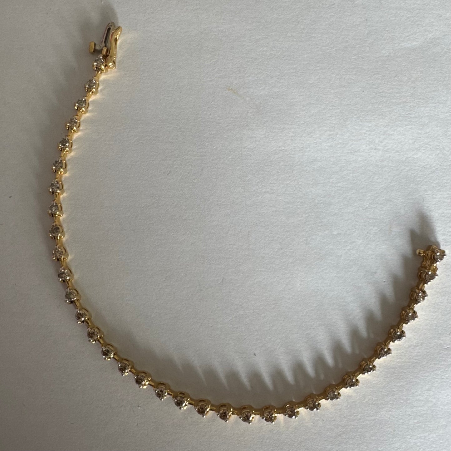 צמיד טניס מזהב צהוב 14 קראט משובץ שורת יהלומים, היוצרים ברק רציף ומראה נקי ועל-זמני.