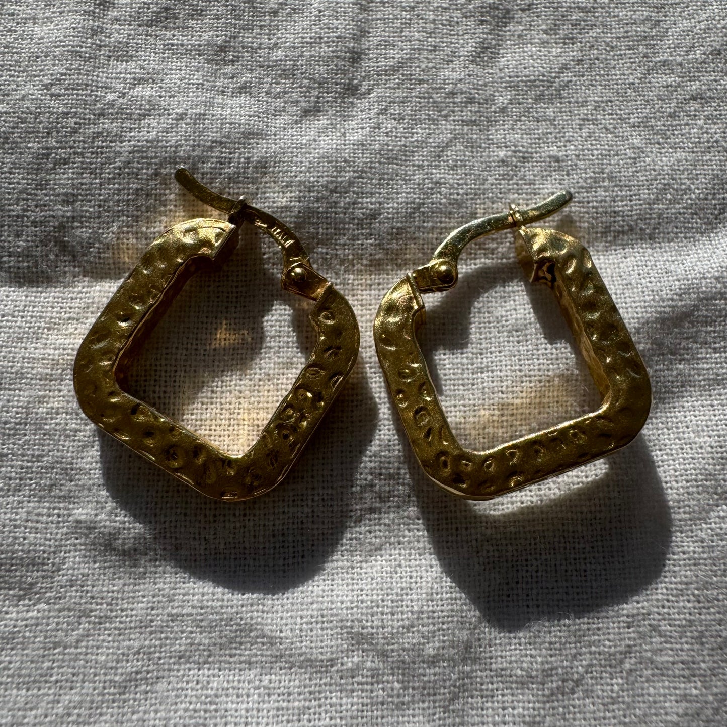 14K gold square hoop earrings with a textured, hammered finish.