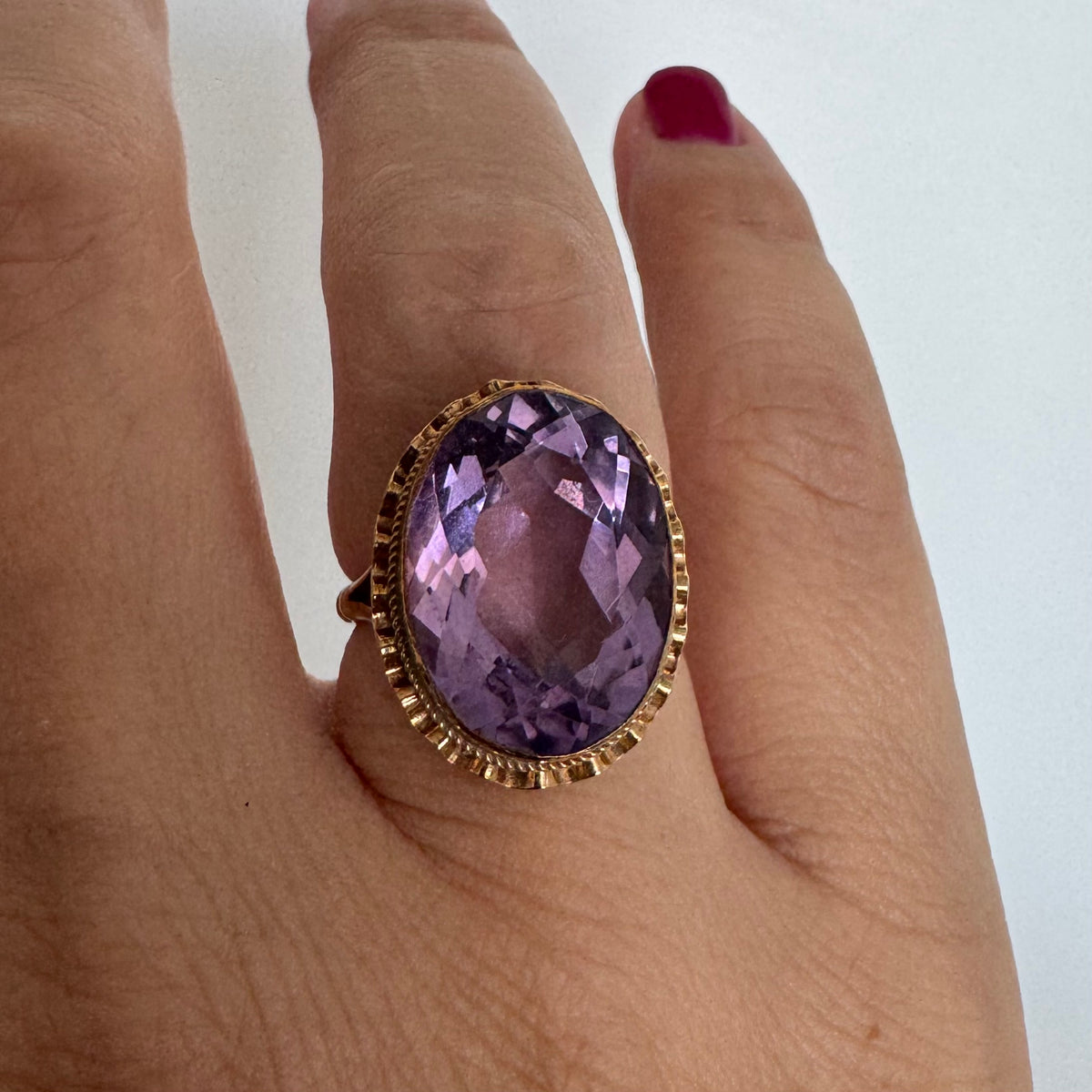 14K gold ring featuring a large oval-cut Amethyst set in an beautifully detailed gold setting
