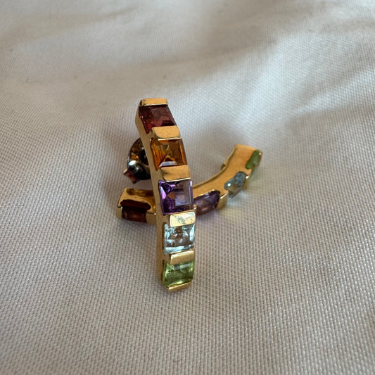 18K gold hoop earrings set with a vibrant line of multi-colored gemstones — including Garnet, Citrine, Amethyst, Peridot, and Blue Topaz.