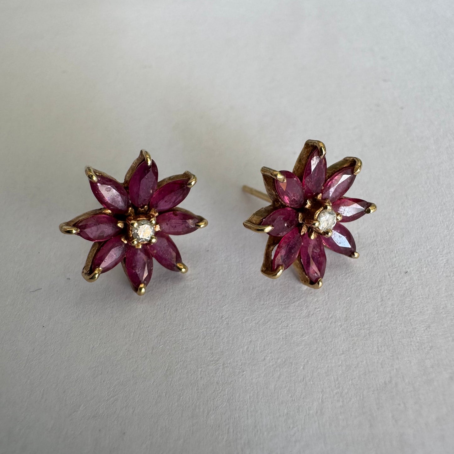 14K gold floral earrings set with marquise-cut Rubies and a small Diamond at the center
