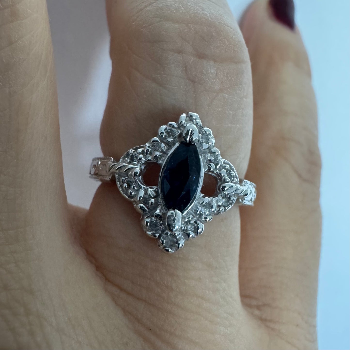 טבעת זהב לבן 14 קראט משובצת אבן ספיר בצבע כחול כהה בחיתוך מרקיזה ומסביב משובצים יהלומים