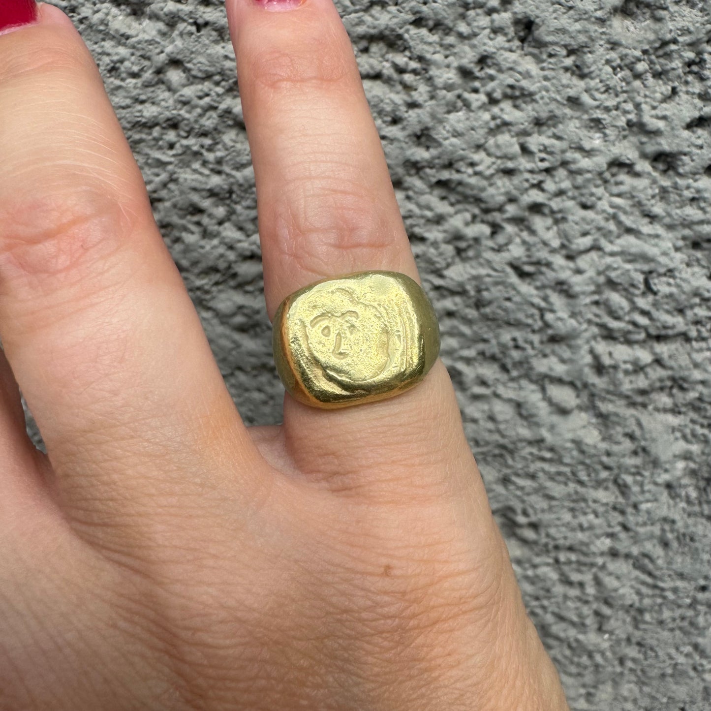 18K gold chunky gold ring with a rustic, organic finish, featuring an engraved abstract face motif at its center.