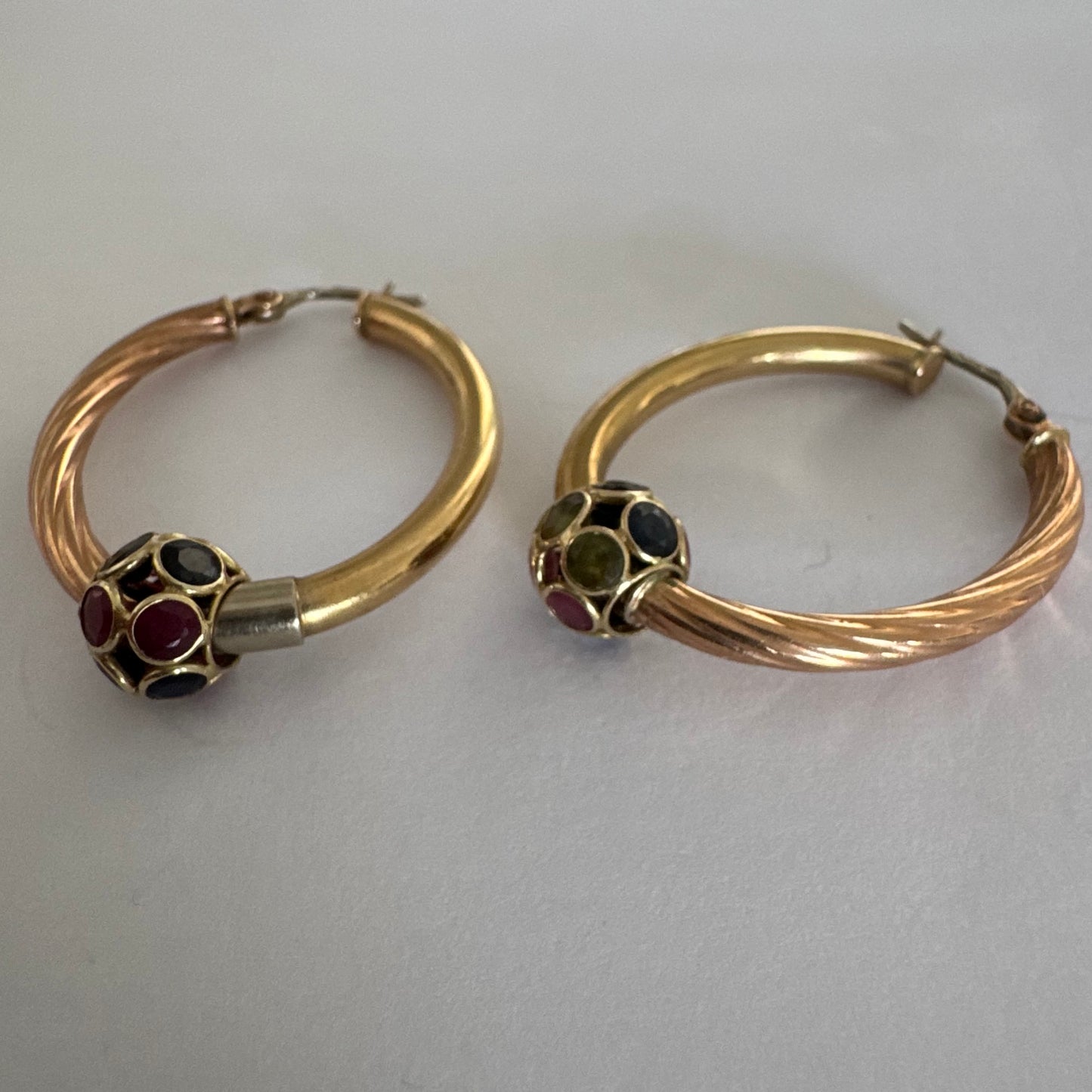 10K gold hoop earrings with a twisted design, set with pink and green Tourmaline.