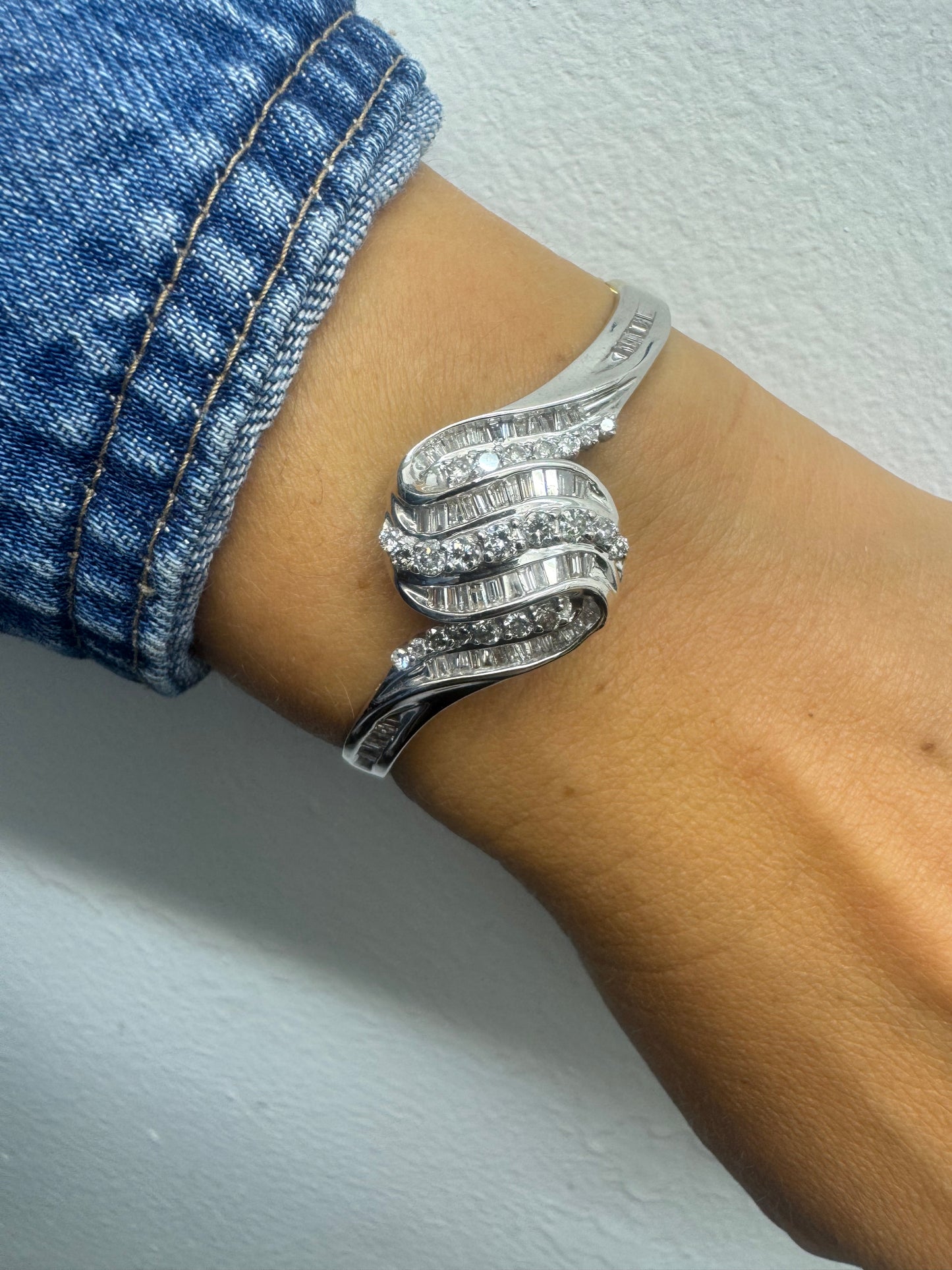 14K gold Hard bracelet featuring a flowing wave design, set with a dazzling mix of round and baguette-cut Diamonds