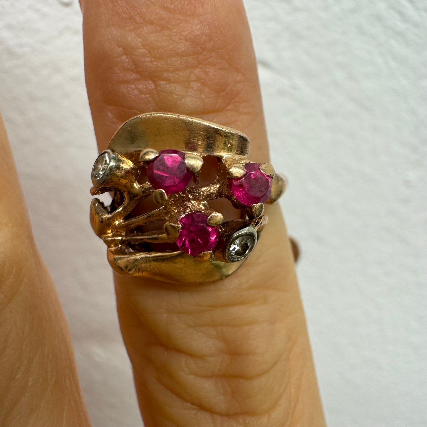 טבעת זהב צהוב 14 קראט, משובצת אבני רובי ושני יהלומים להדגשה, בעיצוב פיסולי ומלא אופי.