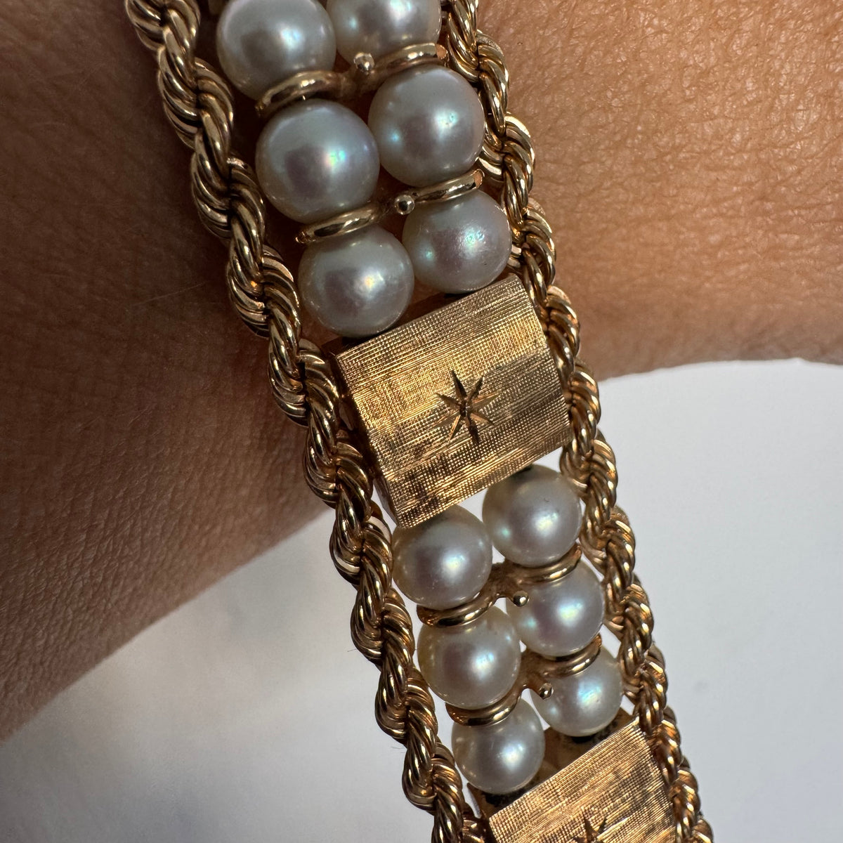 14K gold bracelet set with Pearls, featuring intricate rope-style detailing and textured geometric gold elements.