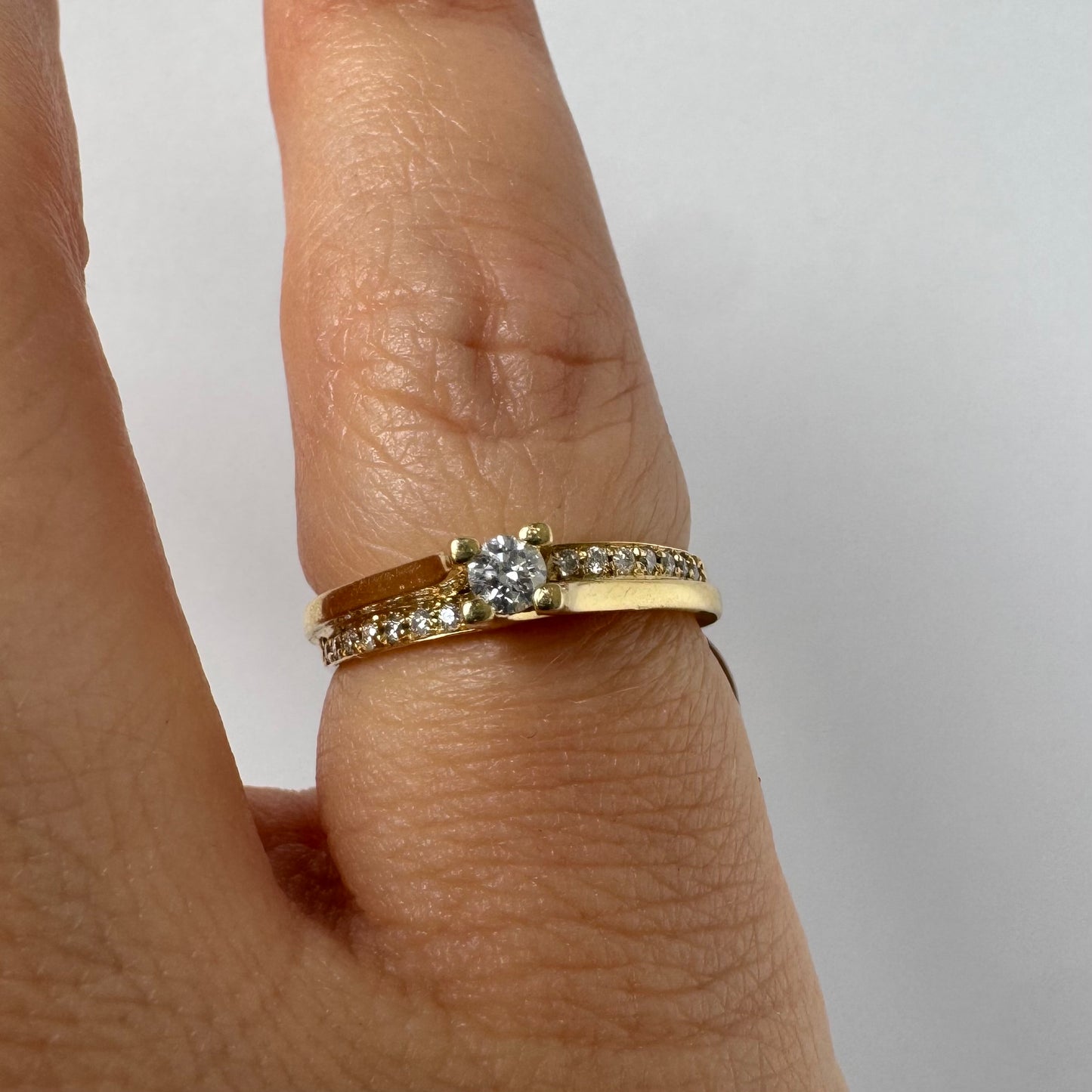 14K yellow gold ring set with a round brilliant-cut diamond and a pavé diamond band ￼