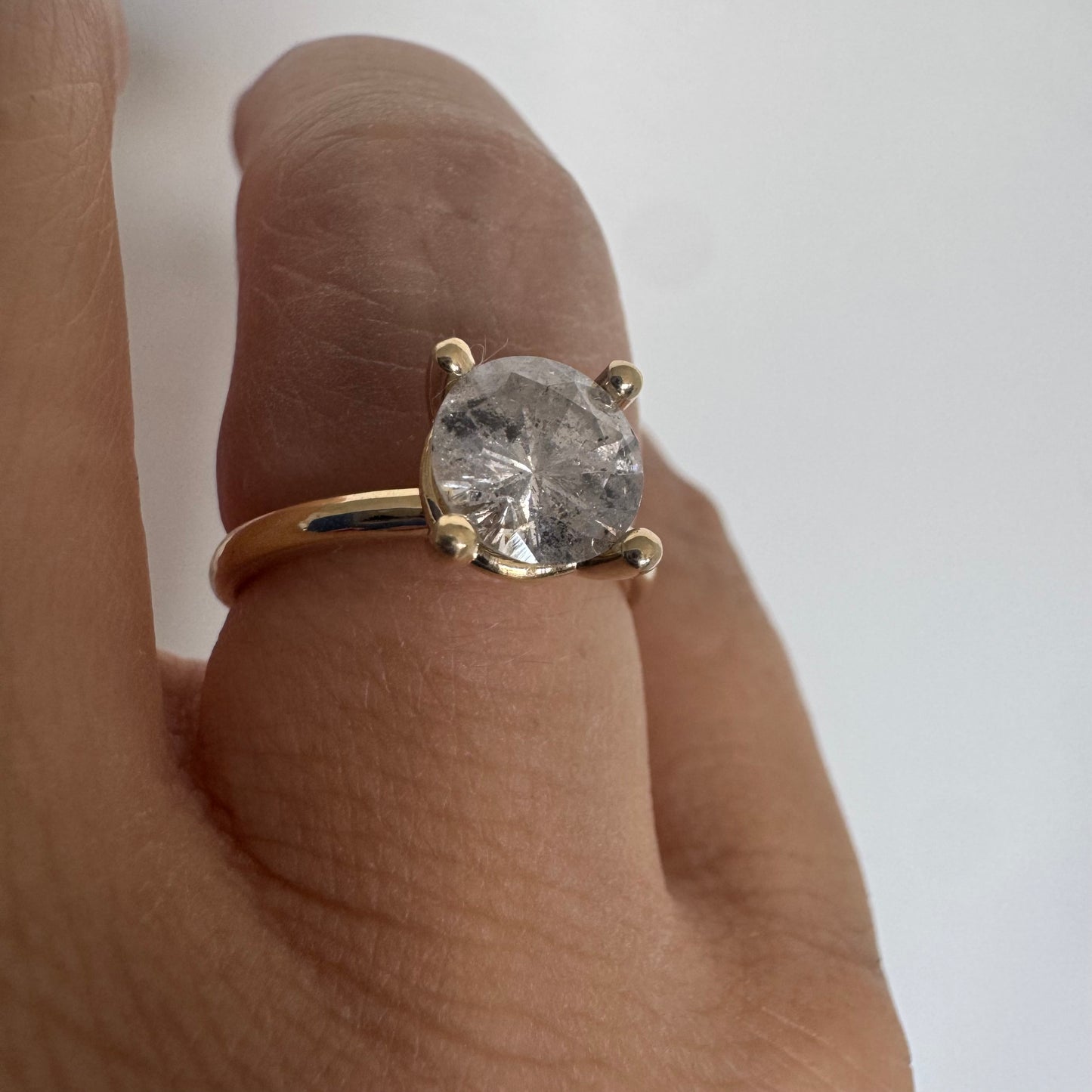 14K gold solitaire ring set with a central round Diamond