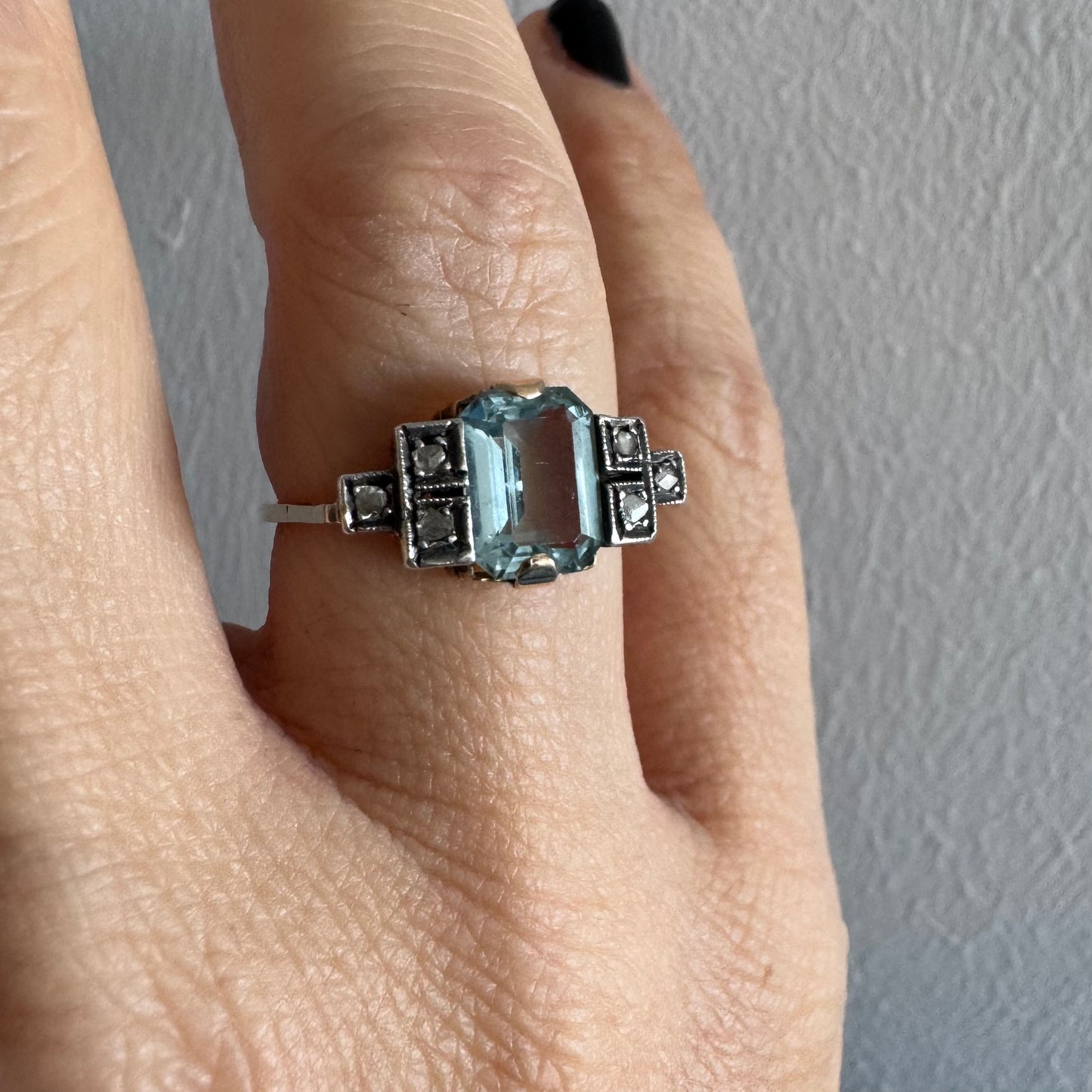 טבעת עתיקה מזהב 14 קראט, משובצת אבן אקוומרין מרכזית בחיתוך מלבני ויהלומים.