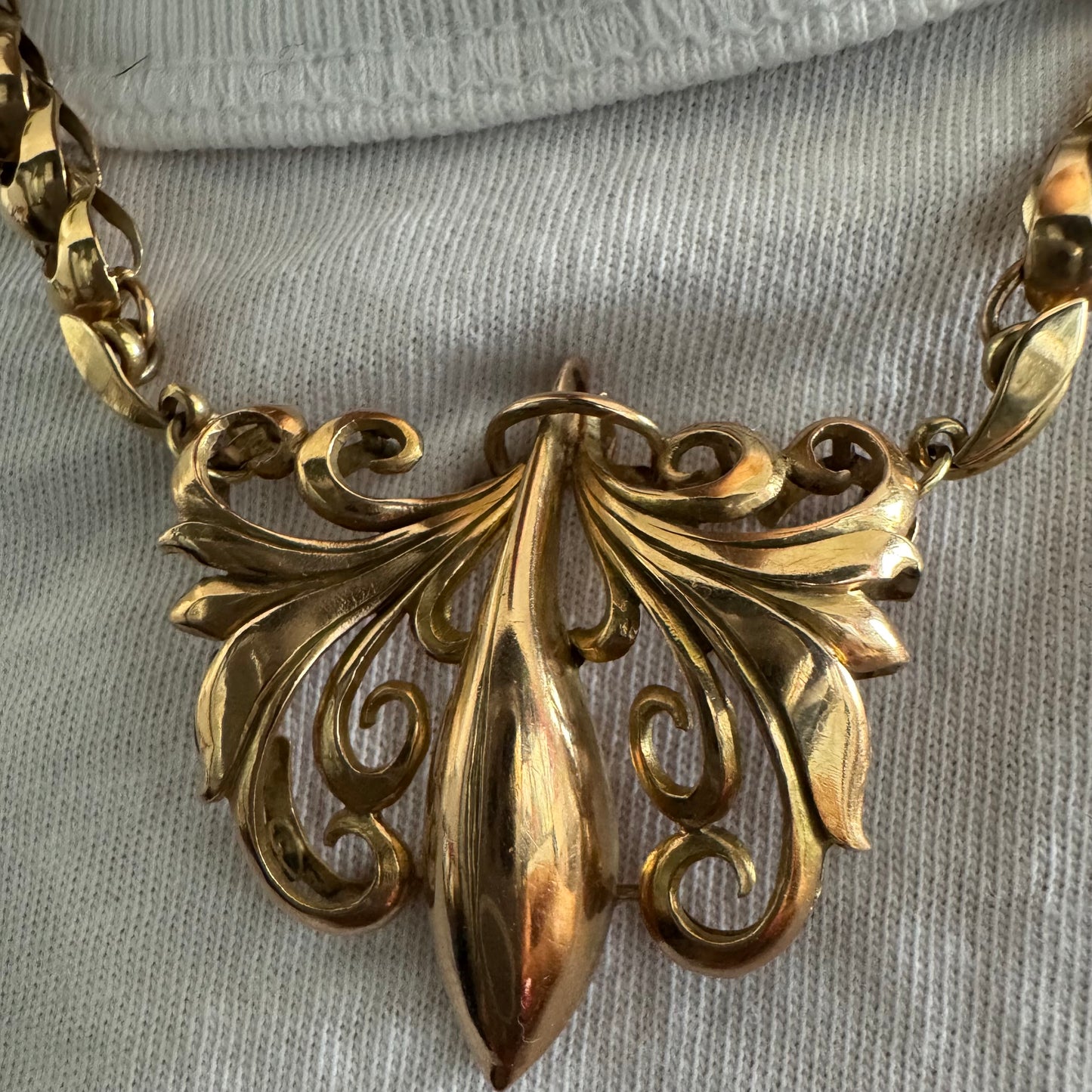 שרשרת זהב 14 קראט בעלת עיטור פלר דה ליס (Fleur-de-lis) אמנותי, המעוצב בקווים מעוגלים של עלי שושן בסגנון אר נובו.