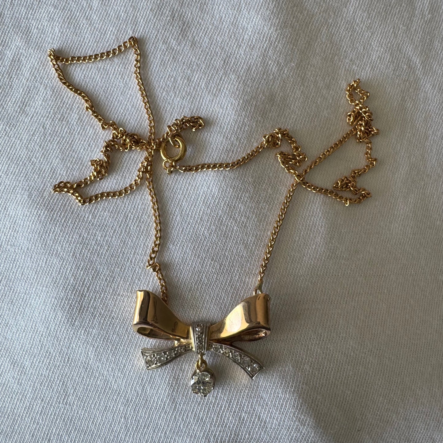 שרשרת זהב 18 קראט עם תליון בצורת סרט קלאסי משובץ יהלומים ונושא יהלום מרכזי תלוי שמוסיף נגיעה של זוהר ואלגנטיות