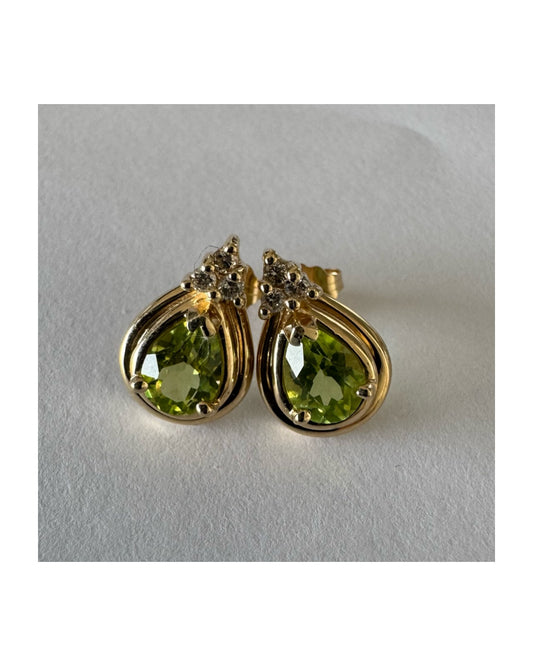 עגילי זהב צהוב 14 קראט משובצים אבני פרידוט בחיתוך טיפה, בגוון ירוק רענן ובוהק. 