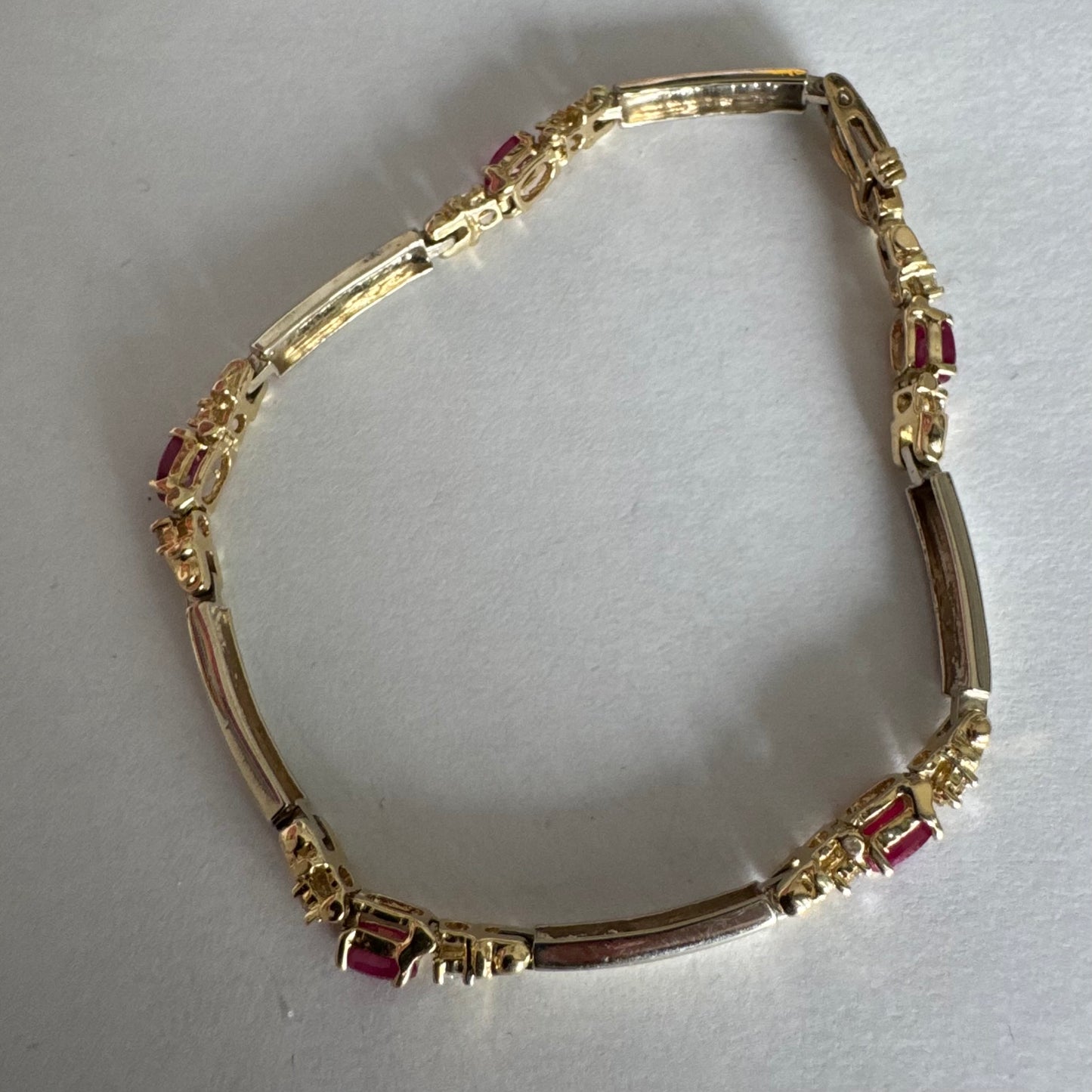 צמיד זהב צהוב 14 קראט משובץ אבני רובי אדומות בחיתוך אובלי, עם יהלומים המשובצים ביניהן להוספת ברק עדין.