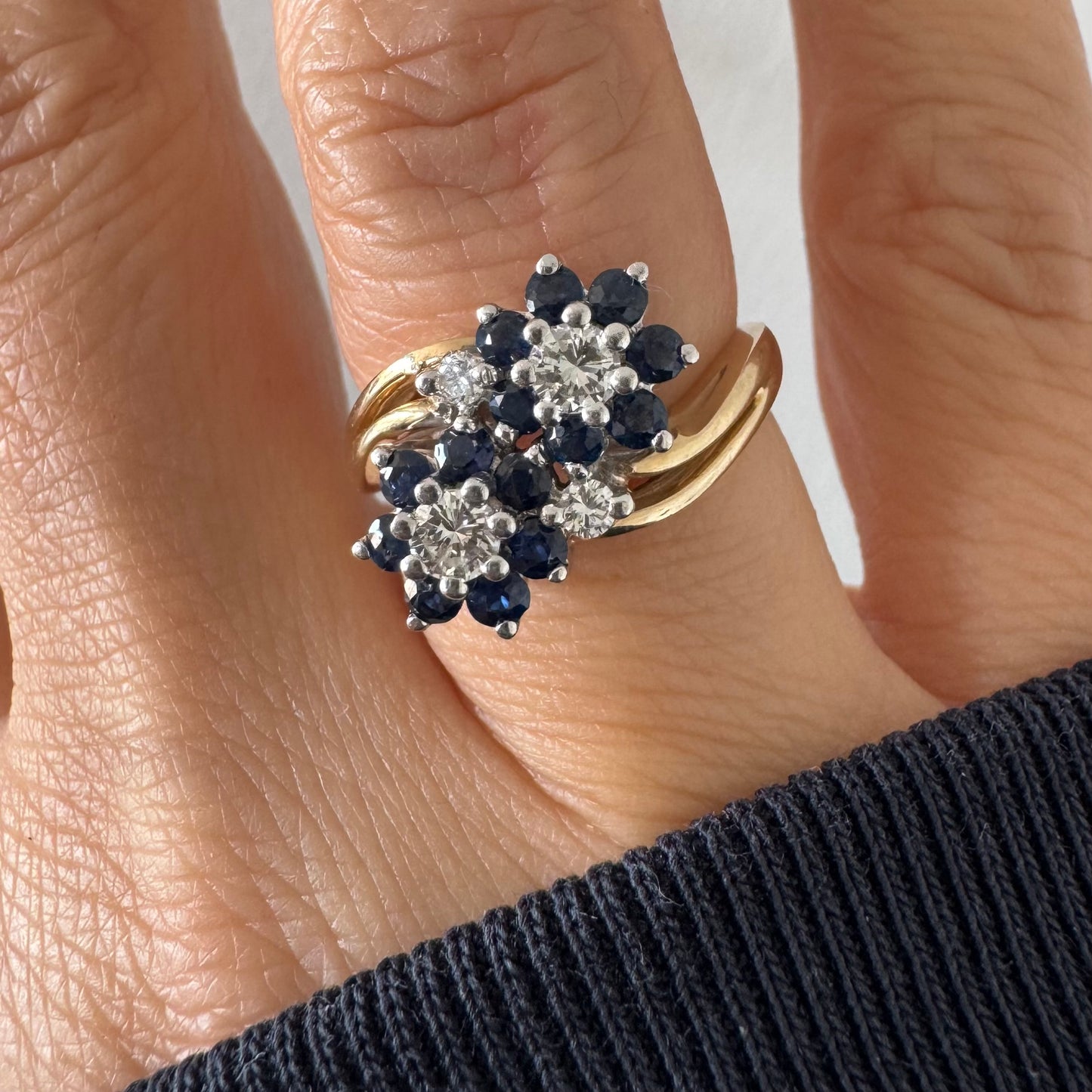 טבעת זהב צהוב 14 קראט משובצת אבני ספיר ויהלומים בעיצוב פרחים כפול.