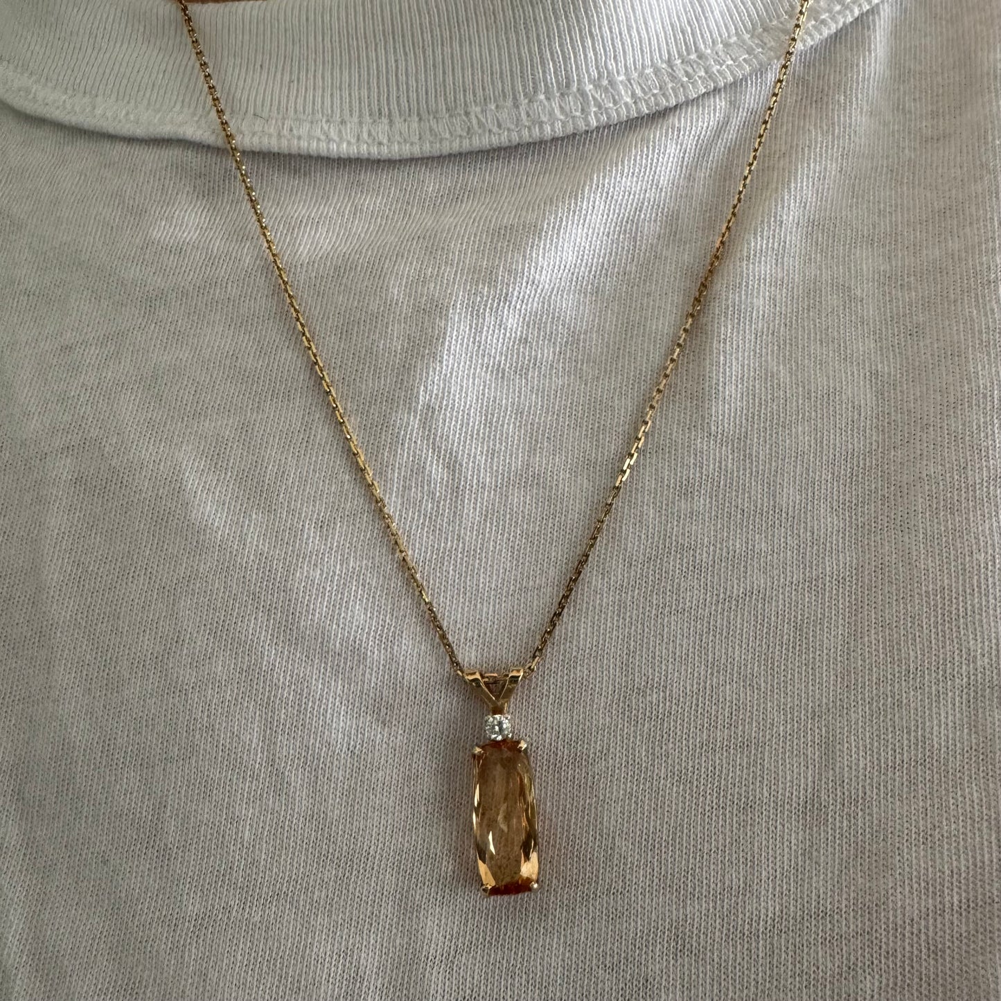 שרשרת זהב 14 קראט עם תליון זהב 14 קראט משובץ אבן קוורץ מלבנית בגוון שמפניה חמים, ומעליה יהלום נוצץ להדגשה עדינה של הברק.