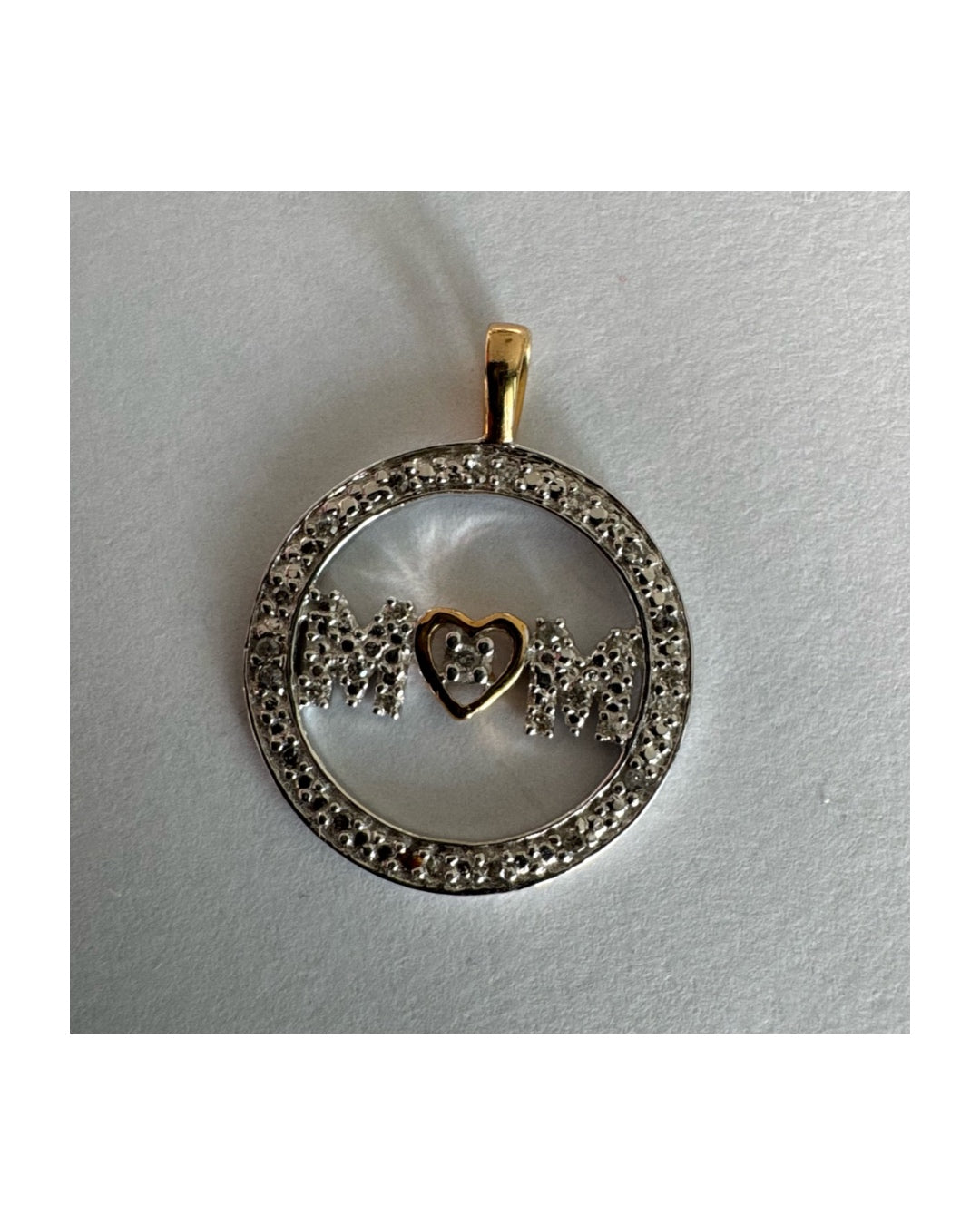 תליון זהב לבן 14 קראט עם הכיתוב ״MOM” מוקף מסגרת יהלומים עדינה.