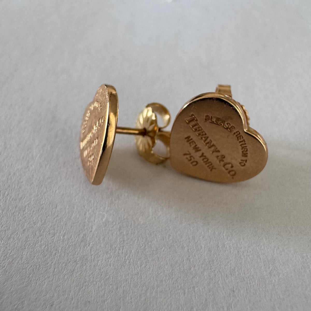 עגילים צמודים של Tiffany &amp; Co. עשויים זהב 18 קראט (750), בעיצוב לב אייקוני עם חריטת “Please Return to Tiffany & Co. New York”. 