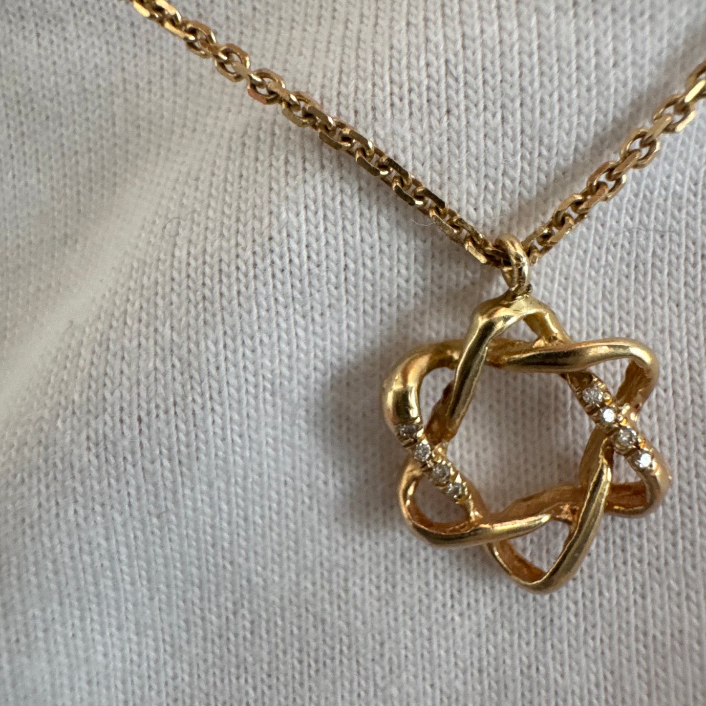 14K gold “Star of David” pendant with a sculptural open design.