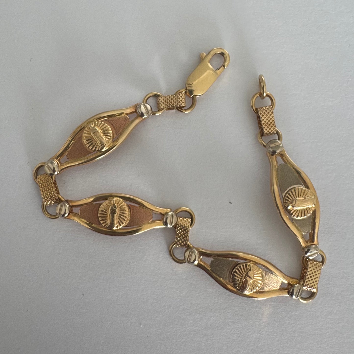 צמיד זהב צהוב 14 קראט עם אלמנט מרכזי בדמות מריה הקדושה, מוקפת קרני אור.