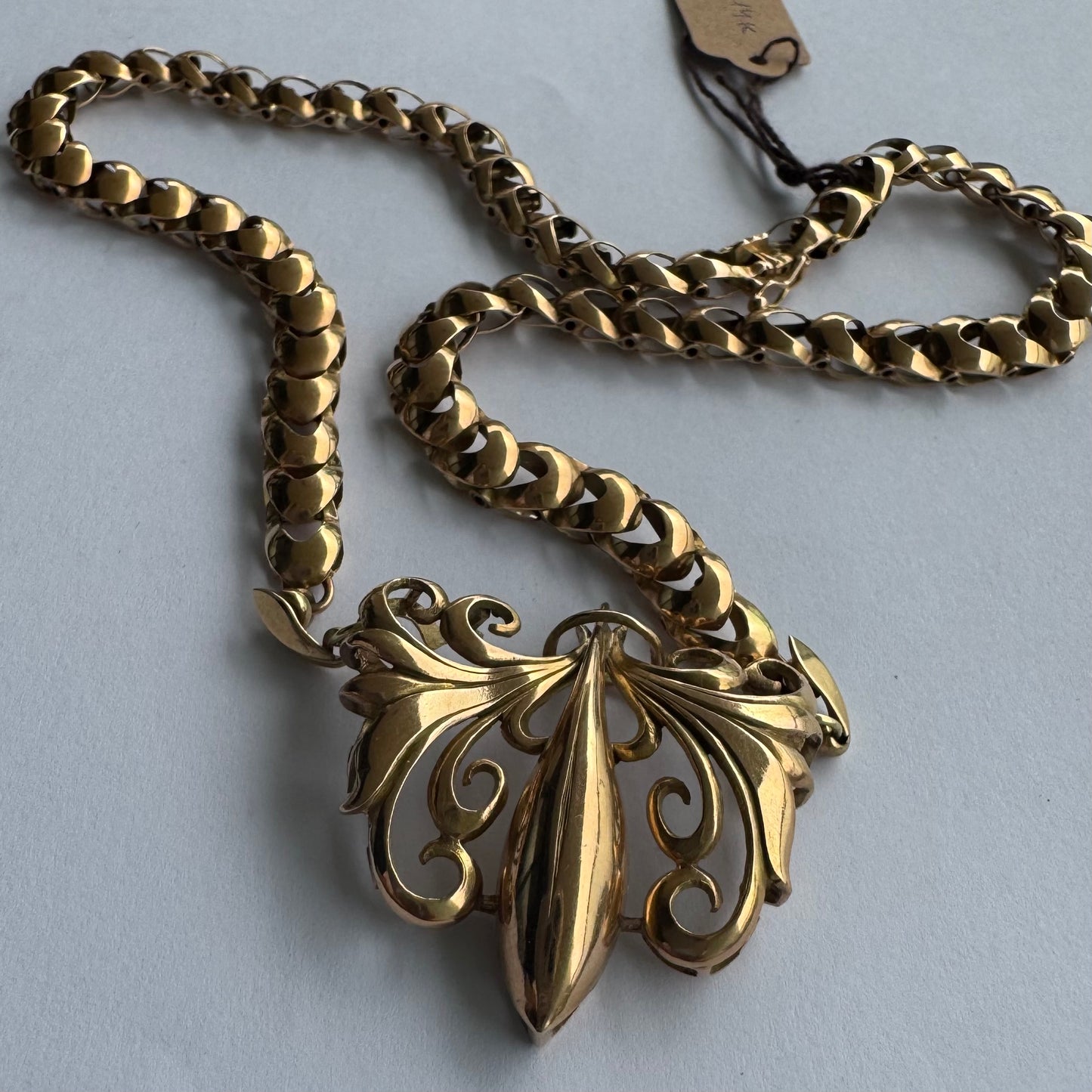 שרשרת זהב 14 קראט בעלת עיטור פלר דה ליס (Fleur-de-lis) אמנותי, המעוצב בקווים מעוגלים של עלי שושן בסגנון אר נובו.