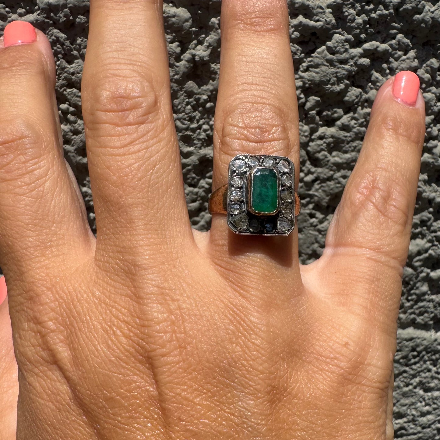 18K gold ring set with a rectangular Emerald and framed by a halo of rose-cut Diamonds