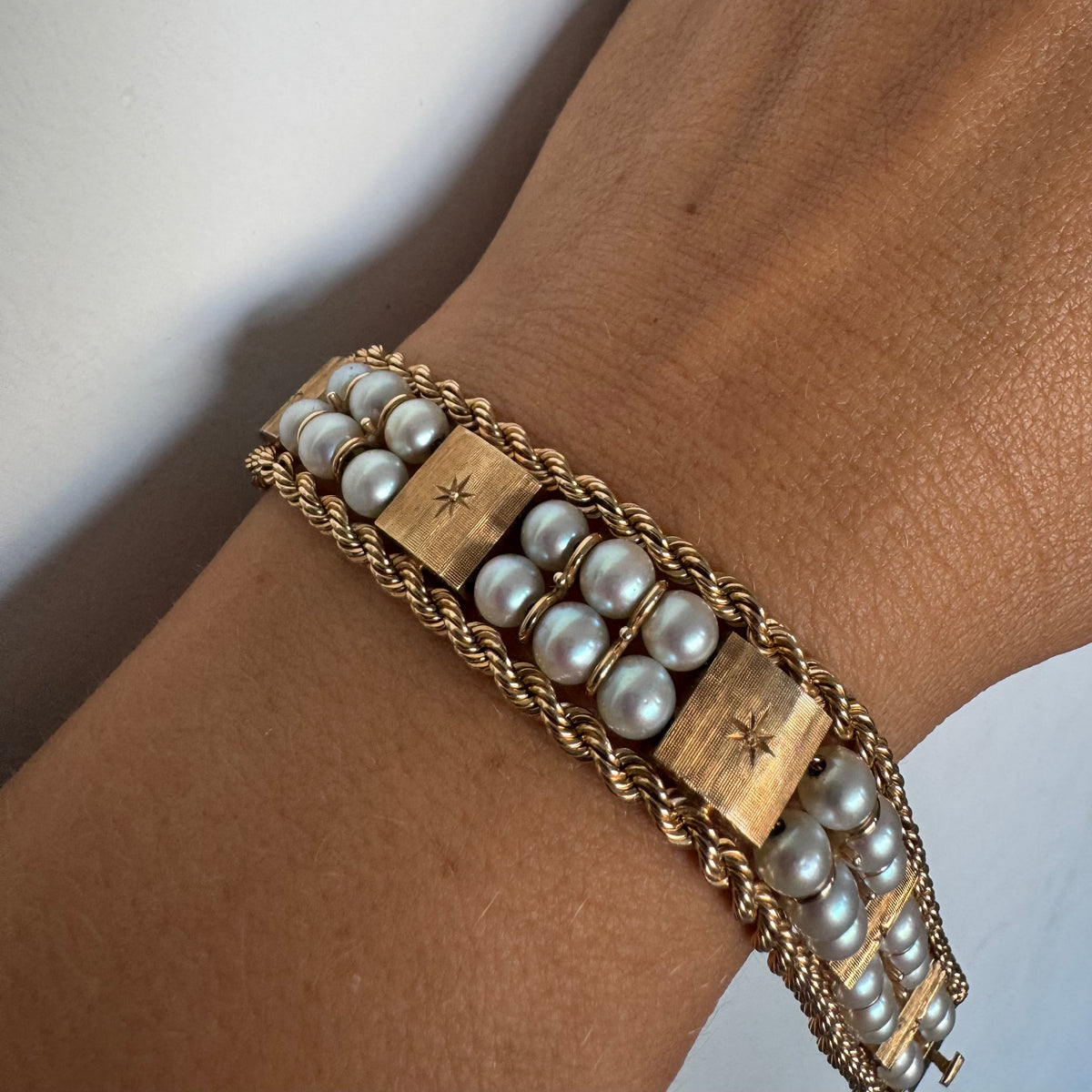 14K gold bracelet set with Pearls, featuring intricate rope-style detailing and textured geometric gold elements.