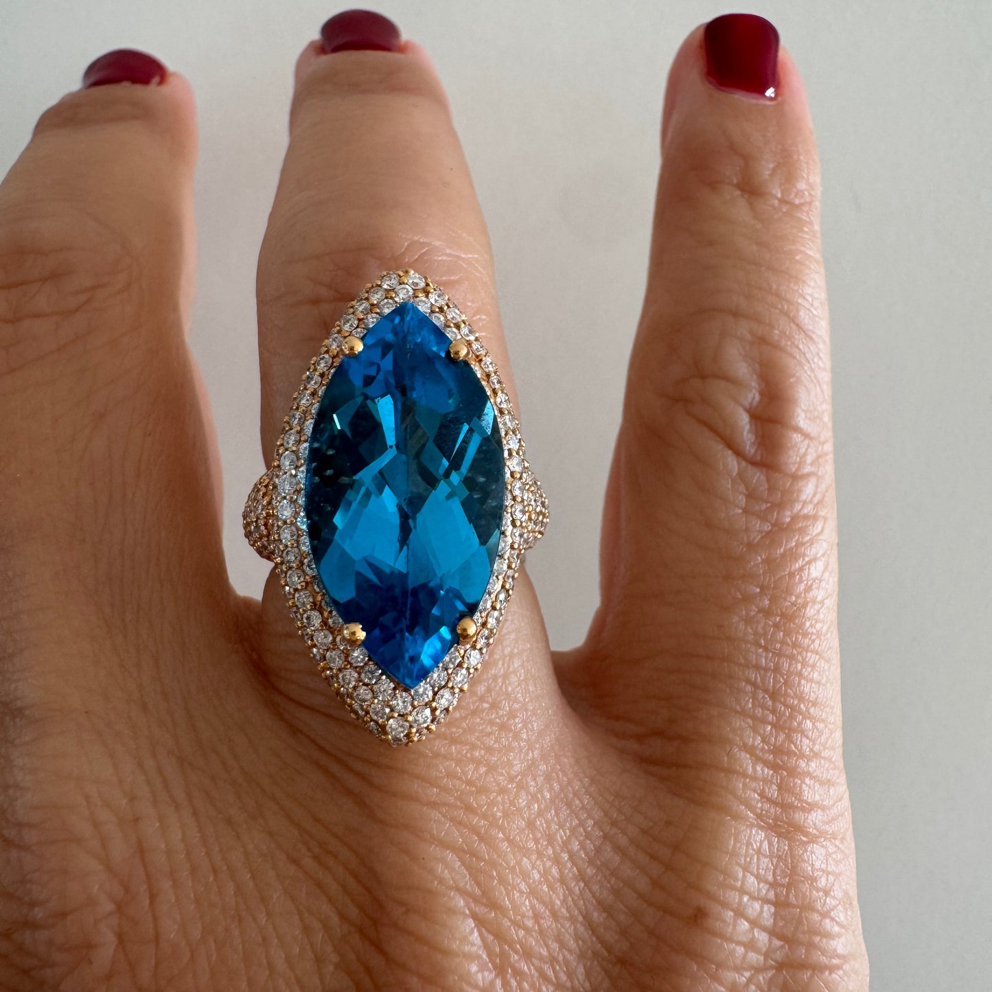 18K gold ring set with a large marquise-cut Blue Topaz gemstone, surrounded by sparkling Diamonds